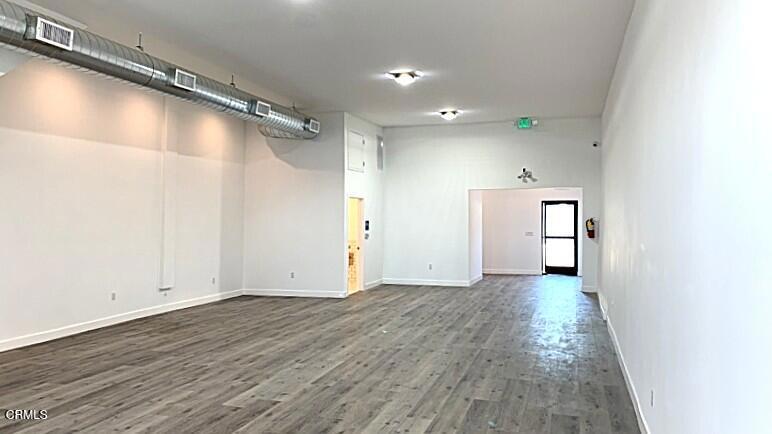 This updated street-level commercial space, part of a multi-use building, is available for immediate occupancy. There is a customer/client reception area, a waiting room, and a small reception office space behind the room with sliding windows. A large open floor plan, approx. 700 sq. ft., with wood laminate flooring, and a rear room that can be used as a media room, break room area, and more. Industrial ducting provides central air and heat amongst the high ceilings. There is a rear entrance door accessible from a rear parking area, accessible behind a motorized sliding gate off the rear alley. This unit comes with two off-street parking spaces. There is a storage area underneath a stairway inside as well. A spacious ADA-compliant bathroom with four-foot-high tile walls all around. Additional electrical outlets along both sides of the walls. This lease amount is inclusive of all NNN expenses. Wired for security cameras and card access..