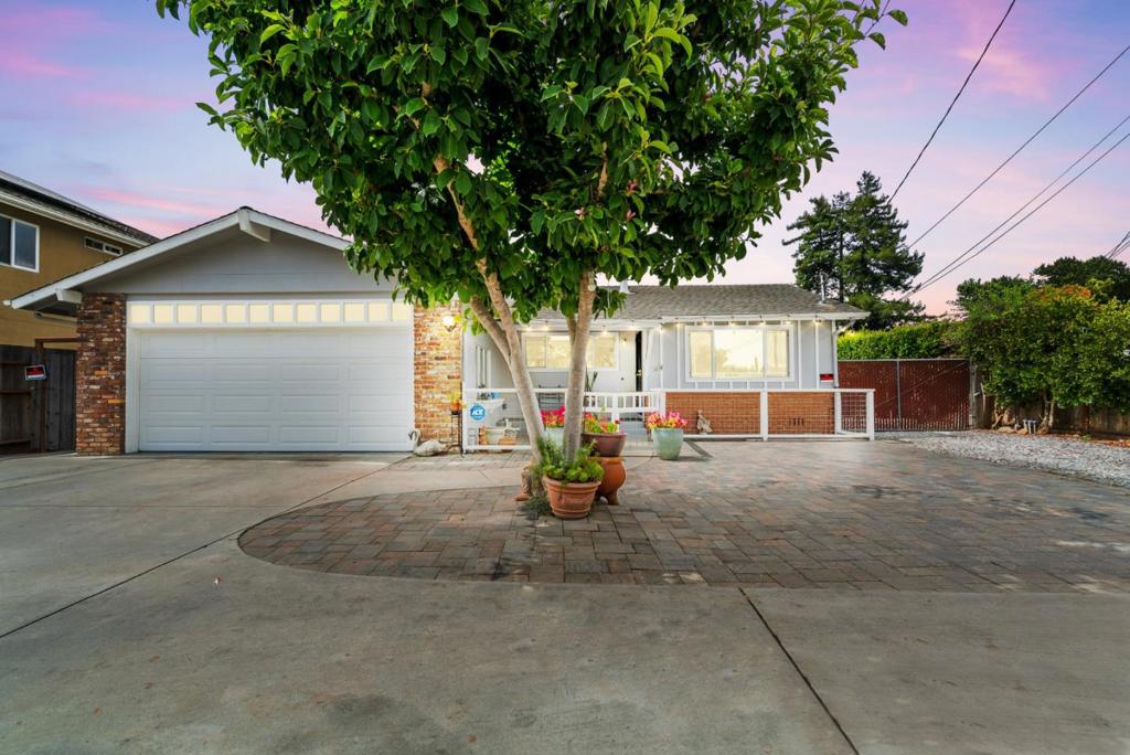 This single-story ranch-style home offers approximately 1,450sqft of living space on a 10,890sqft lot, blending classic design with thoughtful modernization. The interior features oak hardwood floors & recessed lighting, throughout the three bedrooms and two fully renovated bathrooms. The updated kitchen has quartz countertops, a gas cooktop, and an arched ceiling fan opens into the main living room. The family room is anchored by a cozy brick fireplaceideal spaces for gathering and relaxation. Outside, a poured concrete circular driveway leads to the attached two-car garage and offers ample visitor parking. The backyard features a cement patio with block inlays and a covered porch for shaded seating, seamlessly extending indoor comfort outdoors. Beyond the patio, a tool shed, storage shed, and a useable outdoor room provides flexible utility. The remaining yard is a generous expanse of lawn and plantings, inviting outdoor enjoyment. Overall, this ranch-style living has an open flow, integrating indoor and outdoor spaces