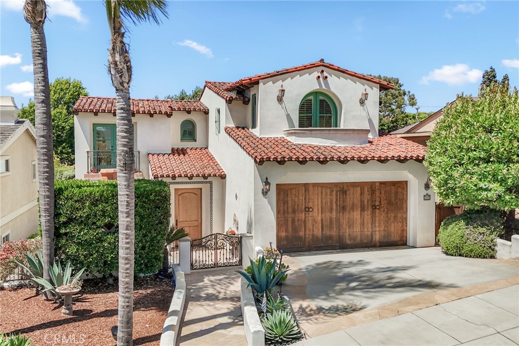 Architectural masterpiece with resort-style elegance on a serene tree-lined street in East Manhattan Beach. This stunning 4-bedroom, 5-bathroom home was meticulously designed by renowned architect Doug Leach, showcasing extraordinary attention to detail throughout.
Soaring ceilings, a dramatic winding staircase, and strategically placed skylights create an atmosphere of casual elegance and light. Your gourmet kitchen becomes the heart of your home—where premium appliances including a SubZero refrigerator/freezer, Viking Range, new wall oven/warming drawer/built-in microwave (2022), and dual Bosch dishwashers work alongside a butler's pantry to make cooking feel effortless, whether you're preparing a quiet breakfast or hosting dinner parties.
French doors from the living room reveal a spectacular backyard oasis featuring an expansive patio and built-in Viking BBQ—perfect for California indoor-outdoor living. The versatile first-floor bedroom offers a private side entrance, functioning beautifully as either guest quarters or a home office. Upstairs, three generously sized bedrooms each feature en-suite bathrooms, while the luxurious primary suite boasts a walk-in closet and opens to a private balcony overlooking lush backyard greenery. The spacious upper landing serves as an ideal den or office, complete with French doors opening to a peaceful balcony with treetop views.
Distinctive features include a charming front patio with wood-burning fireplace, convenient upstairs coffee bar, rich hardwood floors, abundant storage, and an oversized 3-car garage with additional street parking. Located minutes from top-rated schools and everything the South Bay offers, this one-of-a-kind home delivers the perfect blend of architectural distinction and family functionality.