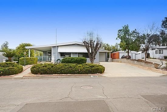 A Great turnkey Manufactured home in The Farm Community located off Bundy Canyon Road with easy access to 15 and 215 highways, This home has 3 bedrooms, 2 baths, Family Room with large bar, Office area, Living room. Great RV garage with FULL RV hookups, plus 2 car tandem or one car with workshop area 2 floor area and storage for most anything like toys or place to run your business from with long driveway and a car port. Remodeled Kitchen has xtra large pantry, cabinets with built in lazy susan. Large covered patio on the front of the home. An oversized central air conditioning and a swamp cooler. Outside, you will enjoy a nice covered front porch, plus a driveway side entrance through the indoor laundry room with sink. The yard is fully landscaped front and back and has sprinklers and drip system. The Backyard has a covered patio and is fenced with gate access to the front yard, side yard, and open land behind the property (no neighbor directly behind you). Major earthquake bracing with marriage bars, laminate flooring, waste disposal, whole house surge protector. The community has multiple pools, spa, community fruit trees, hiking trails, baseball field, tennis court and picnic area with playground and a pond for fishing or just enjoying while sitting on the benches watching the ducks. This is a must see! Low maintinance yards. Turnkey for modern living with an open concept.