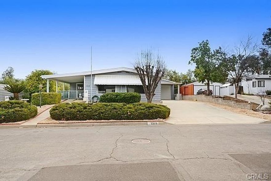 OWNER WILL CARRY...A Great turnkey Manufactured home in The Farm Community located off Bundy Canyon Road with easy access to 15 and 215 highways, This home has 3 bedrooms, 2 baths, Family Room with large bar, Office area, Living room. Great RV garage with FULL RV hookups, plus 2 car tandem or one car with workshop area 2 floor area and storage for most anything like toys or place to run your business from with long driveway and a car port. Remodeled Kitchen has xtra large pantry, cabinets with built in lazy susan. Large covered patio on the front of the home. An oversized central air conditioning and a swamp cooler. Outside, you will enjoy a nice covered front porch, plus a driveway side entrance through the indoor laundry room with sink. The yard is fully landscaped front and back and has sprinklers and drip system. The Backyard has a covered patio and is fenced with gate access to the front yard, side yard, and open land behind the property (no neighbor directly behind you). Major earthquake bracing with marriage bars, laminate flooring, waste disposal, whole house surge protector. The community has multiple pools, spa, community fruit trees, hiking trails, baseball field, tennis court and picnic area with playground and a pond for fishing or just enjoying while sitting on the benches watching the ducks. This is a must see! Low maintinance yards. Turnkey for modern living with an open concept.