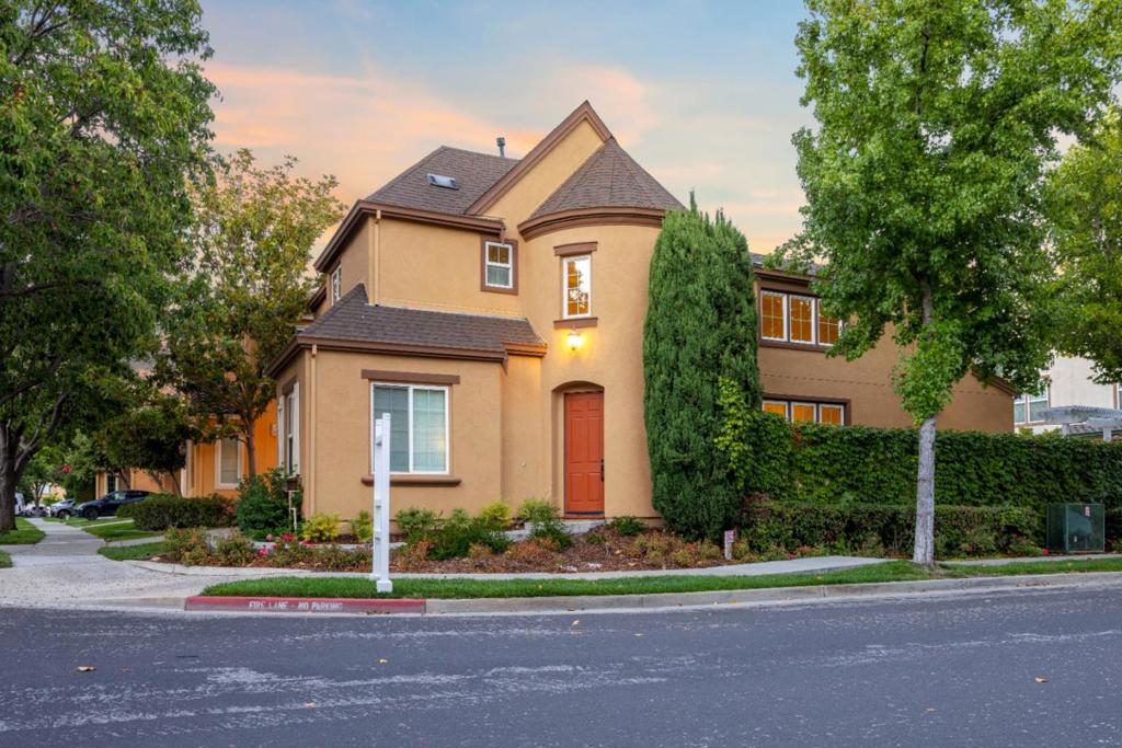 Rarely available, this detached 5-bed, 4-bath home in sought-after Rivermark Village blends modern updates with timeless elegance. Recently refreshed throughout with updated bathrooms, multiple modern light fixtures, and new flooring. Inside the grand foyer, an elegant curved staircase and striking chandelier set the tone for the home's refined character. A first-floor bed with full bath is perfect for guests or in-laws. The formal living room amazes with vaulted ceilings and abundant windows that bathe the space in natural light. Adjacent, the dining room creates a warm, inviting setting for meals. The bright, modern kitchen features off-white cabinetry, contrasting granite countertops, a built-in fridge, stainless steel appliances, and a dining nook. Open to the kitchen, the family room offers a cozy fireplace and custom built-in entertainment center. Upstairs, a beautiful hallway overlooks the living room below. The suite has a private bath, a Jack & Jill bedroom shares another, and the main bedroom features a fully renovated bath with a walk-in smart closet. The professionally landscaped backyard provides ample space for family fun. This home offers effortless access to tech employers, freeways, dining, parks, and trails, placing the best of Silicon Valley at your doorstep.