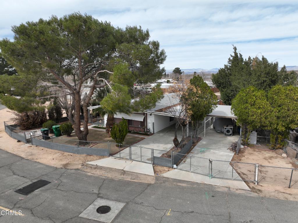 Step into this warm and inviting 2-bedroom, 2-bathroom mobile home nestled in a quiet neighborhood of California City. Brimming with vintage charm, this spacious home offers comfortable living with a cozy, retro flair. The large living room features plush carpeting, rich wood-paneled walls, and ample natural light filtering through classic lace valances and custom blinds. A generously sized plaid sofa and accent chair create the perfect space for relaxation or entertaining guests. The adjoining dining area is ideal for family meals or intimate gatherings, complete with a lovely chandelier, wood dining set, and built-in china cabinets for stylish storage. In the heart of the home, the kitchen boasts a nostalgic design with warm wood cabinetry, vintage tile flooring, and unique wallpaper that adds character. Enjoy casual meals at the cozy breakfast bar, which comfortably seats four. Modern appliances, including a stainless steel refrigerator and built-in oven, blend classic design with convenience. With two comfortable bedrooms and two full bathrooms, this home offers ample space anyone seeking a peaceful desert retreat. Outside, you'll find well-maintained landscaping potential and a welcoming atmosphere in a friendly community. Don't miss the opportunity to own this one-of-a-kind gem in California City -- a home that's ready to be loved and lived in!