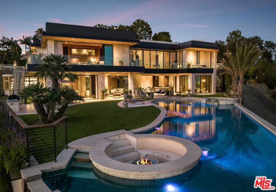 Experience ultimate luxury living in this exclusive Beverly Hills estate. This private, gated compound offers resort-style amenities on a sprawling lot. Upon arrival, you'll be greeted by a striking waterfall and lush landscaping, with ample parking for up to 10 cars. The estate features a hand-tiled Balinese pool, spa, and fire pit, complemented by stunning 180-degree city and ocean views. Enjoy outdoor dining with a full kitchen, expansive grassy yard, and sports/pickleball court. A wellness spa and gym with floor-to-ceiling glass doors open to breathtaking grounds. Inside the spacious main house, you'll find luxurious details including a great room with panoramic views, a gourmet kitchen with a 12-ft island, and a wood-paneled office with a bar. The home offers two primary suites, each with luxurious baths and terraces, plus three additional ensuite bedrooms and a vast outdoor deck. Additional features include a 2-bedroom, 2-bath guest apartment, a state-of-the-art theater, a tequila tasting room, a poker room, a 2000-bottle wine cellar, and a ~3000-sf finished garage with a glass elevator. With perfect finishes throughout, this estate is designed for those seeking an unparalleled rental experience in Beverly Hills.