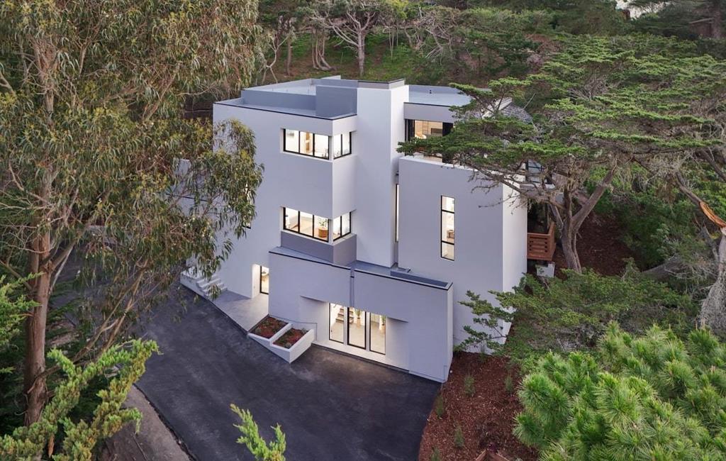 You've never seen one like this before. A brand-new construction on one of the most highly coveted streets in the Carmel Highlands, this staggering residence rises like a pristine white beacon amidst the cypresses, proposing a novel way to revel in the incomparable beauty of the Monterey Peninsula. A chic bedroom suite and full-scale gymnasium round out the first floor, where an elevator waits in a glassed-in reception area to usher guests up to the top levels. Ultra-modern design reigns supreme in every room, with each architectural choice feeling bold, smart, surprising, and intensely rewarding. Imagine windows that stretch all the way from your feet to impossibly high ceilings in all four bedrooms; spa-like ensuite bathrooms with colossal walk-in showers; a freestanding soaking tub; secret decks for sunbathing; and multiple little reading and relaxation nooks encased in glass where you can drift off or drink in sublime ocean views. The top floor primarily comprises an open concept kitchen and living area anchored by views of the Pacific. Fold back the entirety of the glass wall separating this space from a stunning sunroom awash in light, color, and the splendors of nature. Once you have seen a true work of art like this property, there's simply no settling for anything less.