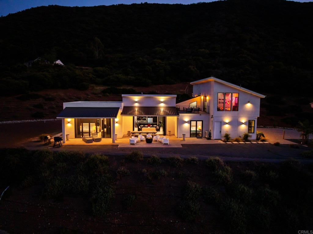 Up a private gated driveway, this modern hilltop estate offers 4.5 panoramic acres, striking architecture, and full self-sufficiency. The 4-bed, 3-bath home features clean lines and floor-to-ceiling 16-ft panoramic glass walls that create seamless indoor-outdoor living. Highlights include a chef’s kitchen with dual ovens and wine fridge, a spa-like primary suite, 8-zone climate control, electric fireplaces, and a 4-car climate-controlled garage with Tesla charger and Tesla Powerwall. Built for independence with a fully owned 10kW solar system, private well, 10,000-gallon water tank, on-site septic, fire-resistant construction, and a newer water softener. RR zoning with no HOA allows for ADUs, horses, retreats, STRs, and other income-generating possibilities. Special financing available. Turn-key and truly one of a kind — with breathtaking views from nearly every room. Seller financing available!