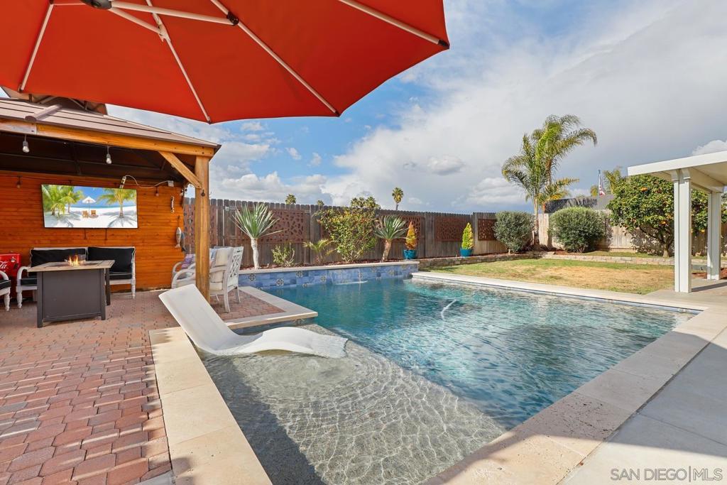 Beautifully Updated Home with Junior ADU & Saltwater Pool in Mission Santa Fe! This 4-bedroom, 3.5-bathroom, 2,057 sq. ft. two-story residence has been thoughtfully upgraded inside and out. Within the last three years, the flooring, kitchen, roof, and bathrooms have all been updated, while the windows were replaced in 2021, offering modern comfort and style throughout. A permitted Junior ADU is incorporated into the first floor as a partial garage conversion, creating the perfect in-law suite or multigenerational living space. It features its own private entry (plus access from the main home), a kitchenette, full bathroom, and combined living/bedroom area. The main kitchen is a showstopper, designed with sleek finishes, modern cabinetry, and quartz countertops. Upstairs, the primary suite includes a beautifully remodeled bathroom, while additional bedrooms and baths provide plenty of space for family or guests. The backyard is an entertainer’s dream with a sparkling saltwater pool, outdoor kitchen/BBQ island, paver patio, gazebo on the pool deck, and mature citrus trees—all framed by updated fencing (approx. 4 years old). A front courtyard adds extra outdoor living space, perfect for morning coffee or evening relaxation. An above-ground spa is also available (negotiable). Additional highlights include leased solar for energy efficiency, an oversized driveway that accommodates up to 4 vehicles, plus garage space for parking and/or storage. Best of all—no HOA and no Mello-Roos! Enjoy a prime location within walking distance to Guajome Regional Park, where you can explore 4.5 miles of trails, ponds, fishing, and birdwatching. All this, plus just minutes to shopping, dining, parks, and freeway access—this home blends versatility, luxury, and functionality. Don’t miss your chance to make it yours!