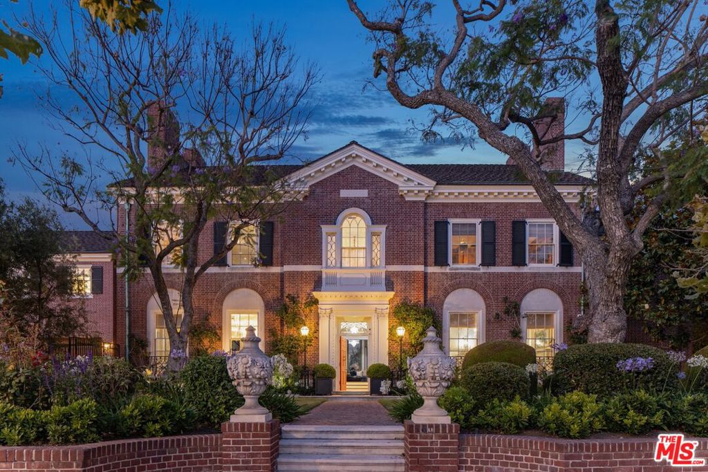 Step into timeless sophistication at "The Griffith Estate", a meticulously restored and expanded Federal-style residence perched above the fairways of the Wilshire Country Club in one of Los Angeles' most coveted neighborhoods. Originally built in 1929 by Jonathan Ring, this rare architectural gem offers sweeping golf course views and a seamless blend of historic elegance and modern luxury. Set on a beautifully landscaped lot, the home showcases hallmark Federal-style elements with symmetrical proportions, classic brickwork, shuttered windows, and refined moldings creating enduring curb appeal. During an extensive renovation, the current owner thoughtfully added approximately 6,000 square feet, elevating the estate while preserving its architectural integrity. Inside, the grand formal living and dining rooms feature original hardwood floors, intricate crown moldings, Zuber wallpaper, and custom built-ins. A chef's kitchen balances form and function with marble countertops, high-end appliances, and abundant cabinetry ideal for both daily living and entertaining. The primary suite is a private retreat with dual bathrooms and dual dressing rooms, offering serene views and exceptional comfort. Additional bedrooms provide flexibility for guests, family, or home office use. A detached guest house adds even more versatility, perfect for extended stays or creative space. This is a rare opportunity to own a piece of Los Angeles history and an iconic estate overlooking the golf course, thoughtfully reimagined for modern living with grace and distinction.