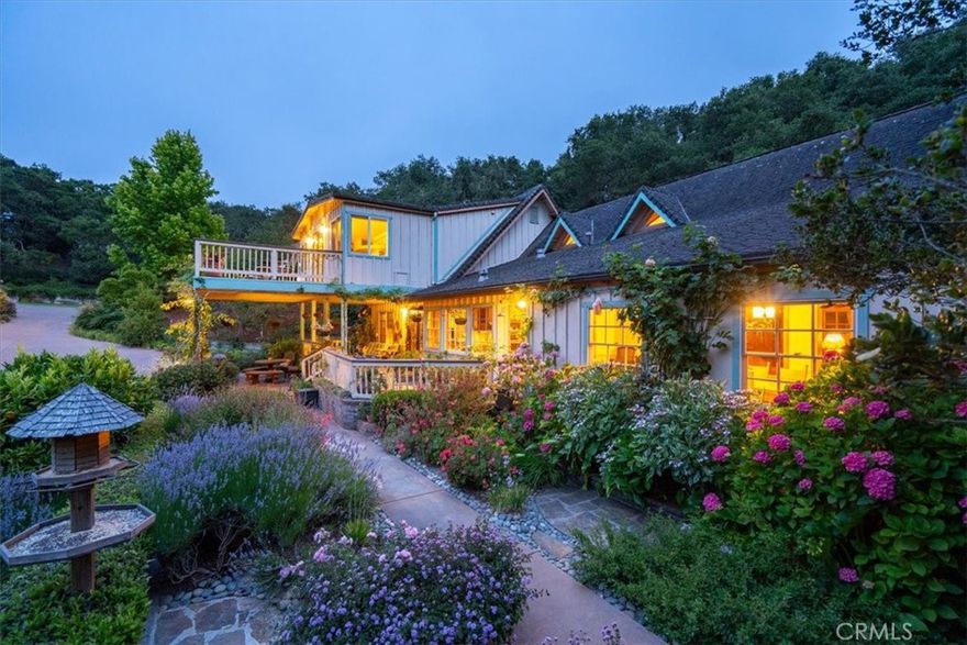 4BD/3BA + guest cottage & workshop on 1.14 lush, private acres.  Nestled behind a private gate at the end of Oak Haven Lane, this 4 bedroom, 3 bathroom home on 1.14 acre offers gorgeous views of the surrounding hills and peaceful, Zen like setting. The charming, detached cottage is 1 bed/1 bath (not included in sq footage or bedroom/bath count) features A/C, Trex deck, and views of the gardens.

Thoughtfully landscaped and lovingly curated over the past 20 years, the lush, oak-studded grounds offer a meditative retreat feel with a calming koi pond and waterfall, fairy and butterfly gardens, meandering meditation paths, multiple flagstone walkways, decks, raised beds, fruit trees including avocado, orange, and apple, sitting areas, bird feeding stations and all of it privately enclosed by 8-foot deer fencing.

With stunning natural pine interiors and abundant windows that bring in natural light and breathtaking views from every room, this is Central Coast living at its finest. The kitchen boasts extensive counter and cabinet space, premium DCS cooktop with griddle, a separate warming drawer, walk in pantry, breakfast bar, under-sink R/O system and inspiring views of the hills and gardens below.  Separate dining room offers plenty of space for memorable gatherings.  The family room creates an ambiance of comfort and relaxation. The open living room features soaring wood-beamed ceilings, a grand fireplace, and panoramic garden views.

Upstairs, the oversized primary suite offers a walk-in closet, a private seating area, dual sinks, jetted tub, walk-in shower, and a spacious private balcony overlooking the gorgeous landscape and surrounding hills. Three additional bedrooms are thoughtfully positioned for guests or family.

Enjoy the large covered front porch surrounded by lush greenery or relax on the sunny deck that overlooks multiple gardens. Lovingly designed to be beautiful in every season.

From the Cottage, a flagstone path leads to a rustic garden shed and steps down to the koi pond and butterfly garden. Up above, is an area for additional parking including a 2-car carport.  Next to the carport is a large workshop with its own deck and seating area and down below is a large shed for additional storage.

This is the ultimate private escape, yet just minutes from the Village of Arroyo Grande and the scenic back way into San Luis Obispo.