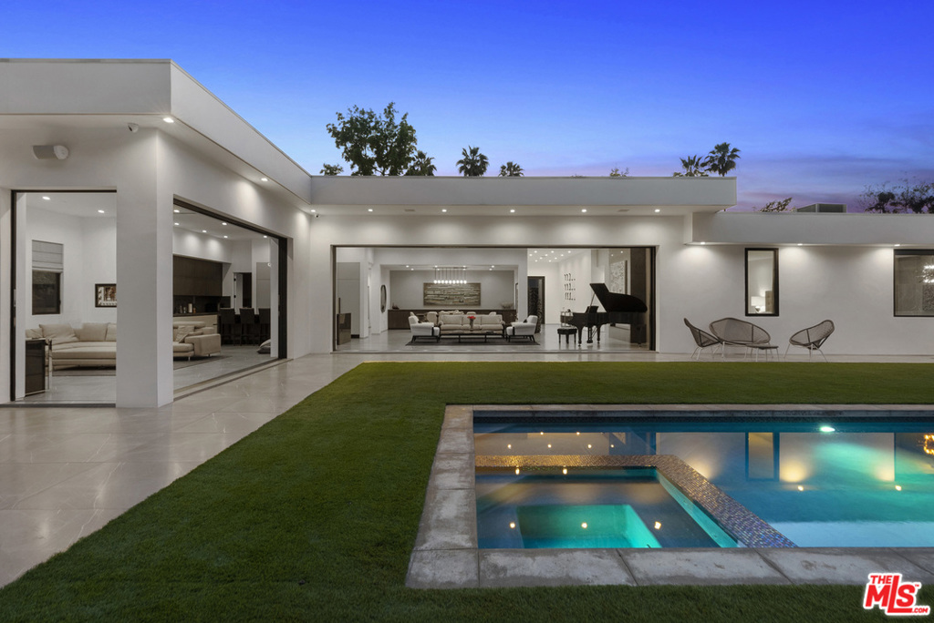 This stunning, private, and sophisticated single-story contemporary in the heart of Trousdale Estates boasts warm, rich interiors, walls of glass, high ceilings, and elegant floor plan. Grand entry invites you to open and comfortable living space, complete with fireplace, easy outdoor access, and automatic sliding doors. Chef's kitchen features high end appliances and separate butler's pantry. Sumptuous and spacious master suite is complete with inviting fireplace, lounge area, luxurious walk-in closet, and direct access to yard and pool. Secondary living room sits among the guest bedrooms, all of which have en-suite bathrooms. Backyard is exceedingly private, featuring grassy pad, pristine, pool, and bar. Located in close proximity to Beverly Hills shops and restaurants.