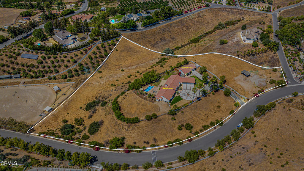 Welcome to 10817 Alysheba Drive, a stunning single-story estate set behind the gates of Moorpark's prestigious Orchard Downs community. Situated on over 5 acres of flat, usable land, this rare property offers space, privacy, and timeless California living just minutes from town.A grand circular driveway leads to the custom-built main residence spanning approximately 3,471 square feet, designed for seamless indoor-outdoor flow. Inside, you'll find 4 spacious bedrooms, 4 bathrooms, formal living and dining rooms with soaring ceilings, and expansive windows that bathe the home in natural light.At the heart of the home, a gourmet kitchen features quartz countertops, custom cabinetry, stainless steel appliances, and a large center island, ideal for entertaining and everyday living. The primary suite is a luxurious retreat with a fireplace, dual walk-in closets, and a spa-style bath with soaking tub and walk-in shower. A private guest suite or office offers flexibility for multi-generational living or working from home.Adding exceptional value is a detached guest house, perfect for extended family, visiting guests, or as a private studio or office. With its own entrance and amenities, this space enhances both functionality and privacy.Step outside to your personal resort, a sparkling pool, covered patio, and expansive grounds ideal for entertaining or future expansion. With over 5.03 acres, there's limitless potential to create your dream lifestyle, whether it's a tennis court, vineyard, horse facilities, or additional structures.Additional highlights include a 3-car garage, dedicated laundry room, and plenty of space for RV or boat parking. Located just minutes from Moorpark Country Club, award-winning schools, and scenic trails, this estate offers the perfect blend of rural tranquility and modern convenience.Whether you're looking to create a multi-generational compound, a dream hobby ranch, or simply enjoy the space and freedom that only a property like this can provide, this home is an unparalleled opportunity to own a legacy estate in the heart of Ventura County.