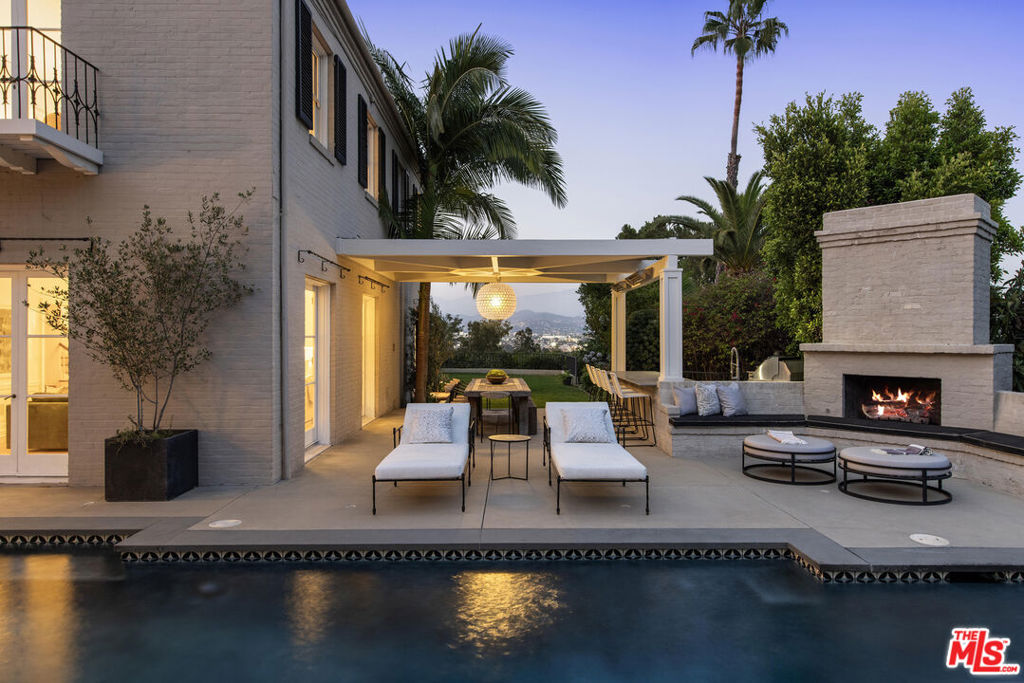 Seller just completed primary suite expansion/restoration and other work. Webber and Spaulding, architects, circa 1928. Located in prime Los Feliz, this sprawling classic Colonial Estate, shrouded behind gates and hidden from the street for complete privacy, was designed to encompass a massive character home plus huge flat yard, accented with sweeping panoramic views of the mountains and the city lights. Sunken lush courtyard entry leads to grand main front hall; opening to sunny living room with fireplace, formal dining room, library and first floor bedroom/office suite; with all rooms opening to the huge yard with original oversized French doors. Culinary fully tiled kitchen with island and stainless appliances features breakfast area and direct access to back yard; with outdoor fireplace, pool, spa and grassy yard with gourmet outdoor kitchen and semi-covered dining patio. Upstairs are 5 bedrooms plus office/gym; all connected by a wide dramatic arched hallway including an exquisite primary suite with private balcony and brand new expanded and redesigned primary bath with soaking tub, deluxe shower, fireplace and sweeping views. Massive family room with fireplace on lower floor opens to a separate section of the yard. Countless original details include built-ins, hardwood floors, classic moldings, original dumbwaiter, plaster walls and double staircases. Tons of storage in the full walk through basement and oenophile's temp-controlled wine cellar. Huge driveway plus to massive 3-car garage with direct access. Extraordinary and truly original elevated living.