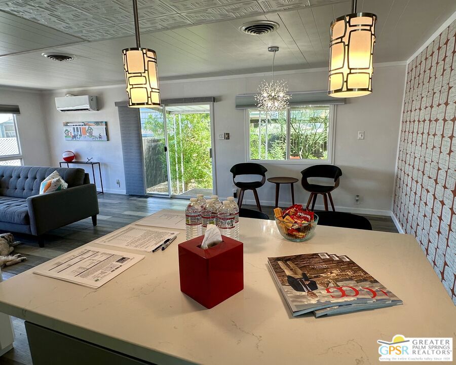 Welcome to this beautifully updated 2 bed 2 bath mobile home offering 960 sq ft of comfortable living space in a prime location close to shops, dining and amenities. This Mid-Mod vibed home, with new lighting fixtures and flooring throughout, boasts a bright open floor plan that effortlessly connects the kitchen, dining and living areas, perfect for everyday living. The primary bedroom features an en-suite bathroom which has been remodeled incorporating a mid-century atmosphere. While the second bedroom, also ideal for a home office, enjoys direct access to the also updated hall bath, creating a flexible layout. The open kitchen shines with new Samsung appliances, quartz countertops and a rolling kitchen island that flows into the dining and living areas for a modern airy feel. Both bedrooms and living room are equipped with efficient money-saving mini-split systems for personalized comfort. The welcoming backyard with a full-length awning covered patio, free standing wooden pergola and soft side hot-tub is perfect for unwinding and for your four-legged family members to play in a secure wooden fenced environment with an outdoor drip system to irrigate the surrounding low maintenance desert landscaping. Other features of this home include a covered carport, offering ease of parking along with additional shade, 2 storage units, landscape lighting, recoated roof, new paint both inside and out, textured wallpaper, an in-unit stacked washer and dryer, electronic fireplace and a tankless water heater. The well-maintained and automated gated entrance to the Royal Palms, a mobile home active 55+ community stands above all others in its amenities such as pickleball courts, pool, spa, putting golf, shuffleboard, large clubhouse with upstairs gym, pool tables, barbeque areas and so much more. This move-in ready mobile home blends functionality, comfort and location into one incredible package. Don't miss this one.