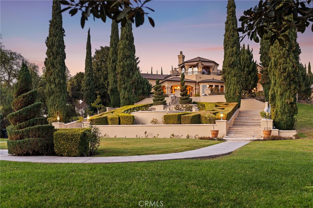Embraced by one of the most sought-after homesites in Laguna Hills' prestigious Nellie Gail Ranch community, this rare estate is ready for your personal touch. Spanning more than four acres, the terraced and private grounds are accessed through custom gates at the end of a hilltop cul-de-sac. This sanctuary offers approximately 8,000 square feet of living space, including seven ensuite bedrooms and nine bathrooms. A generous foyer provides a grand introduction, leading to spacious and inviting rooms, two offices, a chef-inspired kitchen, a gym, and game rooms on each level. Indoor/outdoor living is seamless with numerous French doors opening to patios and gardens. High-quality craftsmanship is evident in the millwork, finishes, and fixtures. The primary suite, located on the main level, opens to a patio with a private spa and features a large bath and a walk-in closet. Outdoors, the estate boasts a pool terrace with a spa, a pool house with a bath and kitchen, a full-size lighted tennis court, expansive lawns, a pond with a waterfall, three stables, and a tack room. The equestrian-zoned property connects to Nellie Gail’s scenic horse trails and includes hidden gardens, meandering pathways, and sunset views. Nellie Gail Ranch is home to a tennis club and equestrian facilities, and the community is conveniently located near The Shops at Mission Viejo, I-5, regional parks, and Laguna Beach. Outstanding schools for all grade levels serve the area. This is a unique opportunity to reimagine one of Orange County's most coveted properties.