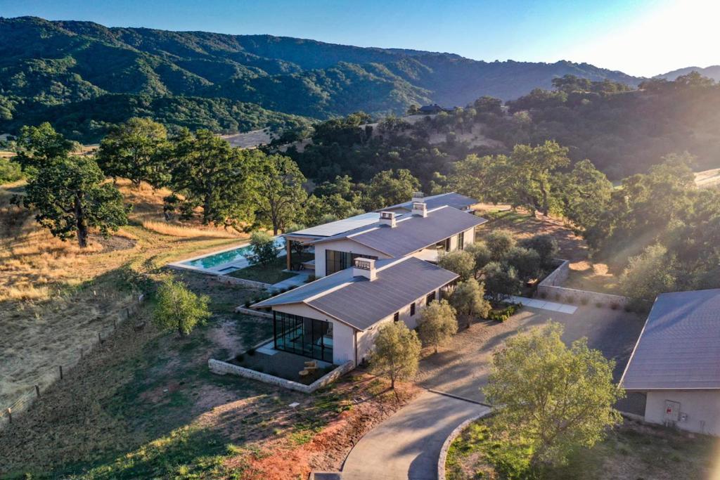 This newly constructed residence artfully bridges the historic reference of a California Classic Ranch Style home with the modern desire and a sensibility of living lightly on the land. A minimalist use of materials with limestone floors, oak cabinetry, massive windows & receding doors integrates everyday life with the astounding natural beauty of The Preserve. The ethereal nature of this design is felt upon arrival through the winding driveway, bearing witness to how lightly the home sits on the land. Architect, Justin Pauly and Ground Studio designed in concert to honor all the land has to offer. Each room enjoys layered views and the interior color palette blends seamlessly with the landscape. There is no back of the house and all systems of comfort and convenience are brilliantly hidden from everyday life. As you move through the house you will feel the ethereal balance of light as the sun moves from east to west over the house and you travel the long wide hallways with windows drawing you into the views. The southern exposure is reserved for the loggia and pool, graced by Swan Hill Olives and down lighting that transform day into night in the same ethereal manner. As you spend more time you will see more detail as the depth of design unveils itself.