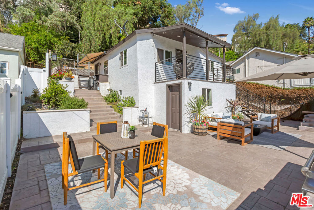 OPEN HOUSE THIS WEEKEND: SATURDAY 9/6 12-3pm & SUNDAY 9/7 3-5pm. "A house on the hills for under $1M." Perched in the serene hills of up-and-coming El Sereno, this secluded mini-compound offers expansive views of city lights and the San Gabriel Mountains. Just minutes from Cal State LA, freeways, dining, shopping, Downtown LA, and Hollywood studios, the location perfectly blends quiet hillside living with vibrant city access. The property features a main house with 2 beds, 2 baths, a dedicated office with its own bathroom below the main level, and a detached 1-bed/1-bath unit above the garage- ideal as a guesthouse, studio, or rental for nearby Cal State LA students (approx. $1,600/month potential). Modern black iron railings surround the property and lead to a balcony where panoramic views greet you before stepping inside to a bright, open floor plan. The contemporary kitchen shines with stainless-steel appliances, custom countertops, and sleek finishes. Both bedrooms feature fully renovated bathrooms with tiled walls, glass shower doors, brushed nickel fixtures, and quartz counters- one en suite, one in the hallway. The detached unit offers a kitchenette, full bath, recessed lighting, and laminate flooring. The lower-level office provides the perfect work-from-home setup. Outdoors, entertain on a spectacular deck with concrete flooring, a custom BBQ island, and breathtaking skyline views. Plug in you EV (with available charging on site) and drive or walk to top-rated IB schools- Farmdale Elementary, El Sereno Middle, and Woodrow Wilson High- offering a complete IB pathway from K12. A rare hillside find under $1M with versatility, income potential, and upgrades throughout.