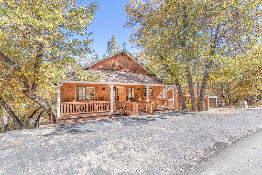 In quiet upper Moonridge, this 3 bedroom, 2 bath home provides a cozy cabin feel with lots of creature comforts! Offered fully furnished, this home is ready for you to just bring your toothbrush! Boasting a main-floor bedroom with deck access, main floor bath, & level entry, this open-floorplan home has woodsy finishes, such as the shaker-style shingle exterior siding, vaulted tongue-in-groove ceilings & accent wall, river rock fireplace with firewood storage nook & adorable raw-edge mantle with bear carving, honey-finish cabinets & wood floors in the bright & airy kitchen, plus more T&G & honey cabinets in the master bedroom & laundry room. Stainless steel refrigerator, stove, dishwasher & microwave bring a modern touch. Skylights & windows abound in this well-lit cabin! Sit or soak for hours enjoying the oaks, pines & peekaboo mountain views from the spacious rear deck with hot tub. Level parking on the sunny side of the street helps with quick snow melt. Cabin décor & proximity to the slopes (1.8 miles) lake (4 miles) & Village (4.2 miles) has made this a successful vacation rental. It could also be a fantastic getaway or permanent residence. This is a must-see!