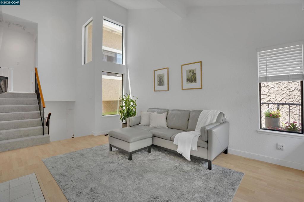 Nestled among the trees & steps from Hidden Lakes Park, this light-filled duet-style townhome is one of the few 3-bedroom models in this highly desirable Martinez neighborhood. The open-concept living & dining room welcomes you with soaring vaulted ceilings, natural light, stylish wood-like flooring, & a cozy fireplace, ideal for a relaxing evening at home. On the entry level, a spacious bedroom with a walk-in closet, full bath, & private sliding-door entrance is perfect for guests or a home office. Upstairs, two additional bedrooms with vaulted ceilings share a modern bathroom featuring a sleek walk-in shower. The bright kitchen showcases beautiful wood cabinetry, a tile backsplash, & light pouring in through the high-set window. The main floor deck is perfect for a quiet morning cup of coffee or weekend BBQs & entertaining guests. Step out your front door to a beautiful low-maintenance & recently astro turfed yard & extended patio. Recently installed solar panels help keep energy costs low while the attached 2-car garage provides ample space for parking & storage. Additional highlights include a community pool, & a prime location near scenic trails, freeways, BART, Diablo Valley College, shopping, dining, top-rated schools, & everything Martinez & Pleasant Hill have to offer.