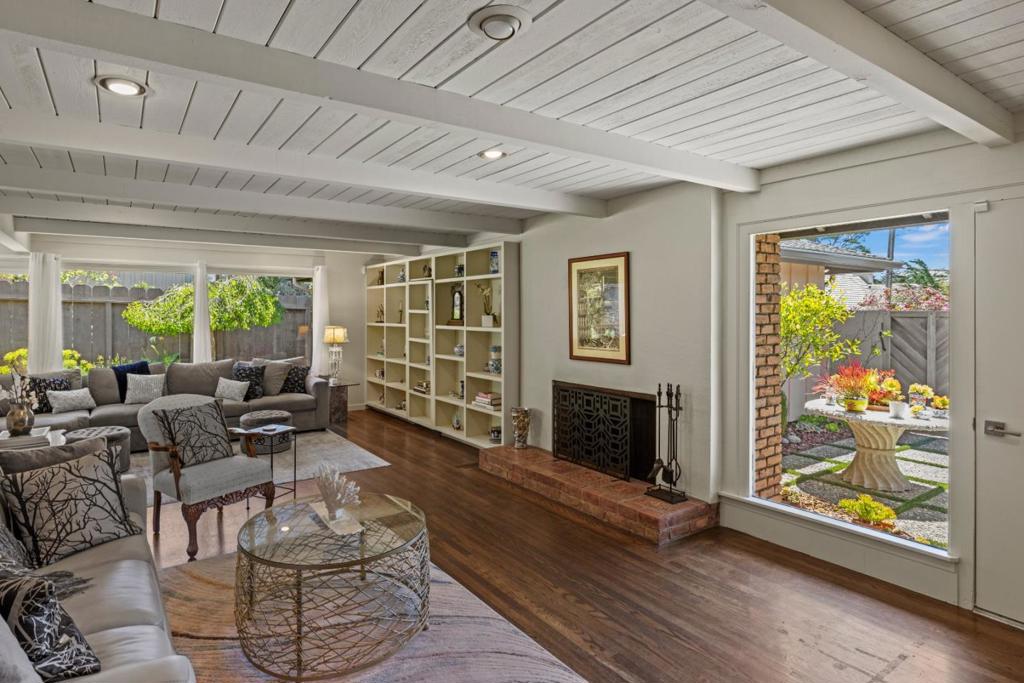 Welcome to your dream home, an impeccable blend of sophisticated design, privacy, convenient location, and exceptional value. Behind a front gate and courtyard on a 6,000 sq.ft. lot, surrounded by flowering gardens is a home of tranquility. This fully furnished, single-level mid-century modern gem is just a short walk to the charming village of Carmel-by-the-Sea. Inside an open-concept great room flooded with natural light from large picture windows, hardwood floors, wood-beamed ceilings, built-in shelving, and a wood-burning fireplace, ideal for entertaining and everyday living. The kitchen fuses form and function, with quartz countertops, stainless steel appliances, and generous cabinetry. Both bathrooms have been redesigned with double vanities, stylish tilework, and a luxurious primary suite with a soaking tub, walk-in shower, and elegant gold accents. Each of the generously sized bedrooms offers dual closets. The garage has been converted into a flexible bonus space - perfect for a home office, art studio, or creative retreat. A separate laundry area adds convenience. This turnkey home delivers standout quality and exceptional value as a full-time residence, a weekend retreat, or a smart investment.