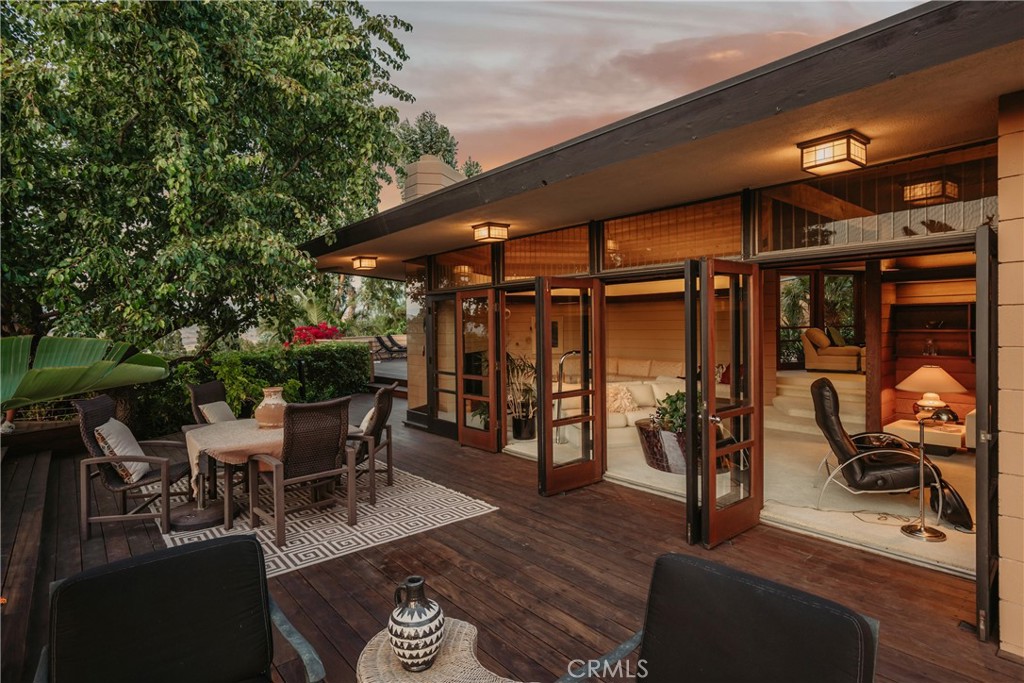 Modernist masterpiece in Cowan Heights, designed by a student of Frank Lloyd Wright and inspired by the legendary Rosenbaum House. Completed in 1965, this architecturally significant home blends midcentury modernism with Wright’s signature Prairie-style philosophy. Set high in the hills of North Tustin, the property offers sweeping, 180 degree panoramic views from Mt. Baldy to Catalina Island, with floor-to-ceiling glass framing the horizon.
The home’s understated street presence and privacy wall open to a warm, modern interior featuring vaulted post-and-beam ceilings, subtle level changes, and a centerpiece fireplace crafted in Wrightian tradition. Natural light pours through corner-butted, clerestory, triangle, and louvered windows. Interior finishes include original ribbon Mahogany cabinetry and interior doors, cinder block walls, and horizontal siding that flows from exterior to interior. A quiet and private escape that doesn’t come along often.
The kitchen features a period-specific Gaggenau 5-burner stove, newer high-end stainless steel appliances, Silestone and granite countertops, and a mirrored wet bar. The primary suite includes a spa-style whirlpool tub, Hansgrohe hardware, and a custom walk-in closet. Additional features include skylights throughout, a 3-car garage, and a detached guest studio.
Outside, nearly 2,500 square feet of wraparound Ironwood decking invite seamless indoor-outdoor living, all built into the hillside in harmony with nature. The landscaped grounds include a private pool tucked into the terrain, serene, not showy. This is more than a home; it’s a rare architectural offering -a work of art - equal parts sculpture, sanctuary, and statement, set on a 26,240 square foot lot with approximately 2,700 square feet of living space, 3 bedrooms, and 3 bathrooms.