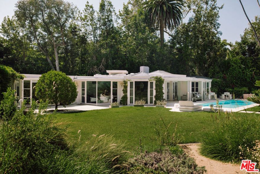 Nestled in the prestigious enclave of Lower Bel Air, 101 Bel Air Rd offers a rare opportunity to own a reimagined single-level estate on nearly an acre of flat and private landscaped grounds. The 4,731 sq. ft. residence combines timeless elegance with modern comfort, offering a seamless indoor outdoor flow ideal for both entertaining and relaxed living. The expansive 39,751 sq. ft. walled and gated lot is a private sanctuary with flourishing grapevines, fruit trees, manicured gardens, winding paths, and tranquil water features. Multiple patios and a large motor court enhance the sense of space and convenience, creating countless places to enjoy Southern California's year-round sunshine. Inside, the formal living room with a striking fireplace sets a sophisticated tone, flowing into the dining room and gourmet kitchen with professional-grade Viking appliances and speciality Subzero refrigerator, skylit ceilings, and a large eat-in island. The adjoining family room with its own fireplace provides the perfect space for gatherings. The primary suite offers a private retreat with a fireplace, spa-like bathroom, custom walk-in closet, and office, while two additional suites, a powder room, and a gym complete the main home. Additional amenities include a detached two-bedroom guesthouse, a media and billiards room, a sparkling expansive pool and spa, firepit, and a custom-built dog run. Originally built in 1947 and thoughtfully updated, this estate blends classic charm with modern luxury in one of Los Angeles' most coveted neighborhoods.