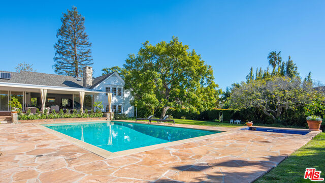 Located in the world-renowned enclave of the Upper Riviera, this five-bedroom property offers the rare benefits of over an acre of usable land. Set in a garden oasis of lofty trees and generous lawns, the beautifully proportioned light-filled home was designed by famed architect Welton Becket. Combining California's indoor/outdoor lifestyle with East Coast grandeur, the main living areas open to a covered veranda overlooking the pool with cabana and tennis court. A media room with vaulted ceiling opens to more grounds where paths meander past rose gardens and fruit trees. Here an enchanting gazebo looks out to a panorama vista with peeks of the city and ocean. With the parklike elegance of the Hamptons, this Riviera property offers the luxury of spacious privacy in a most desirable location.