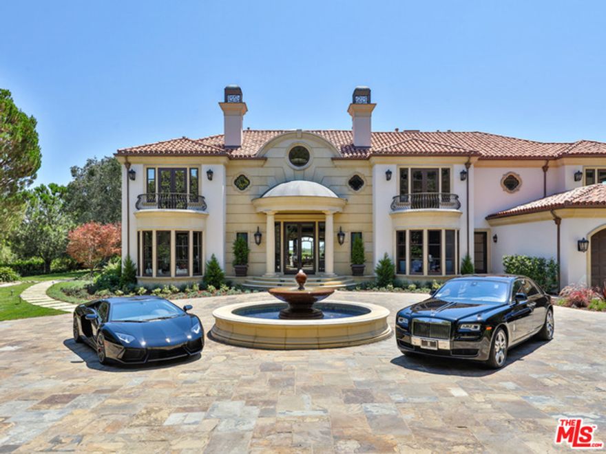 At the top of a private, gated drive in the exclusive Beverly Park community enclave, this gorgeous tennis court estate has been stunningly revamped and reimagined. Sitting on nearly two acres, with unparalleled city and canyon views, this sprawling gem epitomizes laid-back California luxury. A large motor court and fountain beckon you into a spacious, light-filled home with refined details throughout. Traditional interiors include both formal and informal living and dining spaces, study, chef's kitchen, and powder room. Upstairs are three generous en-suite guest rooms and a large master suite with dual bathrooms, walk-in closets, and balcony overlooking the grounds. Outdoor area is complete with palm trees, rolling lawns, Grecian pool, spa, and reflection pond, as well as a guest pavilion with full kitchen and open living area. Amenities and finishes such as marble and onyx countertops, wood details, impeccable landscaping, and magnificent views complete this Beverly Hills offering.