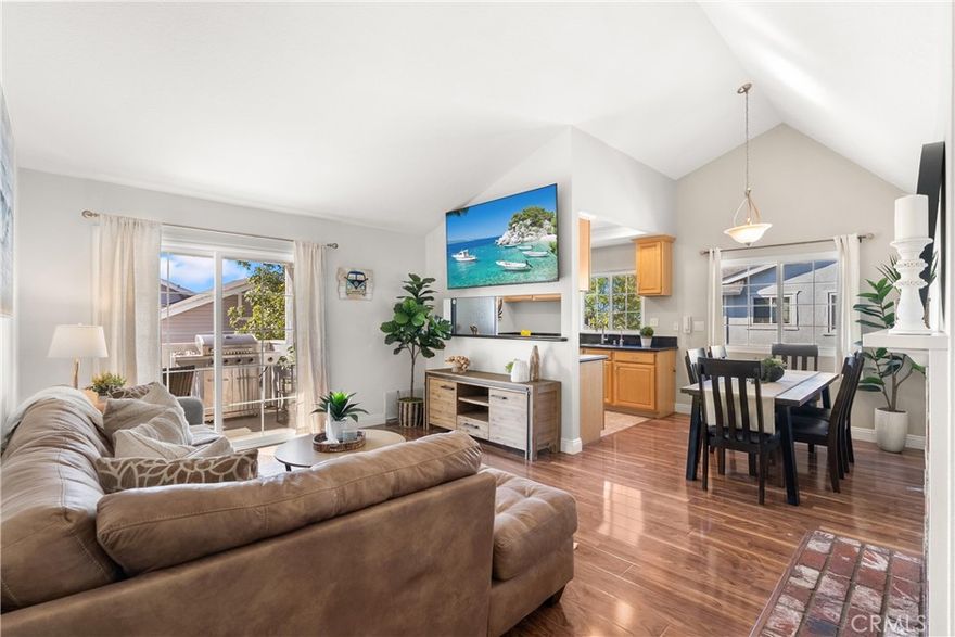 Welcome to your Huntington Beach haven! This bright and airy 2-bedroom, 2-bath condo has it all: soaring ceilings, a cozy brick fireplace, and an open floor plan that flows effortlessly onto a private deck, perfect for morning coffee or evening relaxation. The upgraded kitchen shines with a gas stove, built-in microwave, ample drawers, and plenty of storage for all your culinary adventures.  Retreat to the spacious primary suite with a walk-in closet and dual-sink ensuite, while the second bedroom boasts mirrored closets, a ceiling fan, and lots of natural light. Just steps away, a separate bonus room with its own entrance, window, and door makes a perfect home office, studio, or extra storage space. Additional perks include brand new dual pane windows and sliding doors, and interior laundry area with overhead storage cabinetry.  Enjoy 2 covered side-by-side parking spaces in a gated garage, guest parking just across, and a secure entrance for peace of mind. The Capewoods community adds low HOA dues, a sparkling pool, spa, and clubhouse. Centrally located near shopping, restaurants, Huntington Central Park, and just minutes from Huntington Beach Pier, this condo is a dream starter home or investor gem. Style, comfort, and convenience all wrapped into one inviting package!