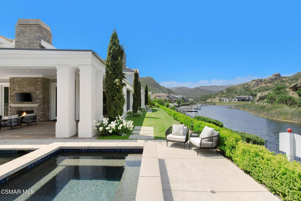 A Hampton-Style Masterpiece with Private Dock on Lake Sherwood. Welcome to an exquisite Hampton-style estate--a true embodiment of timeless sophistication and refined luxury--nestled on a quiet cul-de-sac behind the prestigious guard gates of Sherwood Country Club.With direct lakefront access, this extraordinary residence seamlessly blends elegant design, modern comfort, and the serenity of lakeside living. Spanning approximately 6,459 square feet, the two-story home offers 5 spacious bedrooms, 5 luxurious bathrooms, and a powder room for guests.The formal dining room and elegant office/den lead into a gourmet kitchen outfitted with premium appliances and designer finishes--ideal for both intimate dinners and grand-scale entertaining. At the heart of the home, the expansive Great Room embraces the Southern California lifestyle with seamless indoor-outdoor flow, opening to a generous patio perfect for al fresco dining or relaxing under the stars.This smart home features Lutron lighting, advanced home automation, and a state-of-the-art solar power system, offering the perfect balance of convenience, efficiency, and innovation.For water enthusiasts, the private dock provides direct access to the crystal-clear waters of Lake Sherwood, inviting endless days of boating, paddleboarding, and waterfront enjoyment.Framed by the majestic Santa Monica Mountains, the estate captures breathtaking panoramic views and a peaceful sense of seclusion--while remaining just minutes from Lake Sherwood Country Club, with its championship golf course, tennis courts, fine dining, and fitness amenities, as well as all the upscale offerings of the surrounding community.