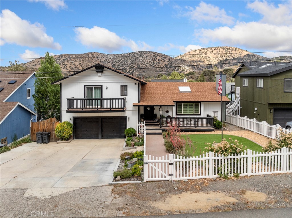 Welcome to 5419 Locarno Drive — a beautifully updated 4-bedroom, 3-bathroom mountain home located in a desirable Wrightwood neighborhood. This 1,950 sqft residence sits on a 7,700+/- sqft lot and blends cozy charm with modern upgrades throughout. Step inside to a warm and inviting living space, complete with a wood-burning pellet stove fireplace, natural light pouring in from the skylight, and elegant wood-style flooring throughout. The open-concept kitchen is a showstopper — featuring rich cabinetry, granite countertops, stainless steel appliances, and bar seating at the island, making it ideal for both everyday living and entertaining. The spacious primary suite feels like a private retreat, with its own balcony, a gorgeous dual-sink vanity, a sleek walk-in shower, and modern fixtures throughout. Three additional bedrooms (one of the lower level) offer flexibility for guests or an office space. Enjoy mountain mornings or evening sunsets from the charming front porch, framed by a white picket fence and manicured turf yard that enhances the home’s curb appeal. Out back, you'll find a fully fenced yard with a large covered patio, a basketball hoop, and a concrete pad — perfect for play, relaxation, or entertaining under the stars. Additional storage can be found underneath the deck as well as a small unfinished basement/crawl space that can be accessed from the backyard. Don’t miss your chance to own this turnkey home in one of Wrightwood’s most desirable neighborhoods.