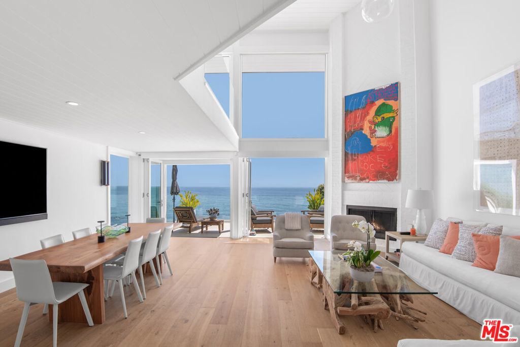 This well-designed impeccably maintained architectural beach house has all the comforts and style you want in your dream Malibu Road beach home, along with south facing views of the ocean, beach, bay, Malibu Colony, Palos Verdes and Catalina. Clad in white brick with Mahogany wood (same as Nobu) 22' plank garage doors and a unique Ipanema black and white marble mosaic driveway, this home exudes style. Soaring 36' Cathedral ceilings, white oak engineered wide plank floors with glass railings inside and out around all decks. Folding floor-to-ceiling glass doors allow maximum ocean views. There are open living and dining areas and a beautiful galley kitchen with atrium garden window, a wet bar and powder room. The primary loft suite has a seating area and a private oceanside balcony. Charming third floor "eagles' nest" bedroom suite with powder room and stunning ocean views. Upper and lower decks with a built-in BBQ, sink and fridge and huge storage room for your beach toys, paddle and surfboards, etc. There is a well fitted-out two-car garage and gate-secured side paths on both sides of home. This home is situated in a well-protected position on a rock promontory above the ocean.