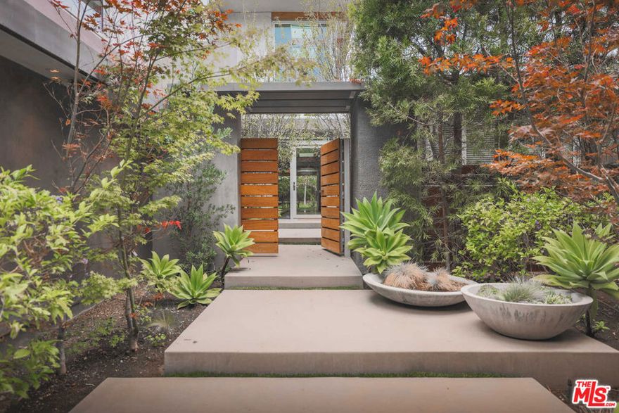 Rare opportunity: Two properties 1700 Mandeville Cyn Rd and 1710 Mandeville Cyn Rd combined into one sweeping 1.27 acre lot (aggregating 56,454 SF) off lower Mandeville Canyon Road only one block above Sunset Blvd. Tucked away down a long private driveway (the first driveway past the stop sign at Westridge), owned exclusively by the property, this quiet, secluded compound boasts a mid-century modern architectural gem designed by master architect Richard Dorman and recently restored and enhanced by acclaimed architect John Bertram. It is a home of warmth, lightness and calm, with high ceilings, wood posts and beams, an abundance of natural light, wide plank, matte white oak floors, and sliding walls of glass, all looking out to a magical, verdant property. It has an enormous flat yard (rare in this area) and a gently sloping hillside of beautiful specimen trees which frame the estate, providing exceptional privacy and giving a magical, verdant quality to the property. The property has large garden boxes, for growing vegetables, fruit and flowers, and, halfway up the hillside, a second flat pad large enough for a studio, a children's play area or a beautiful dinner party. Downstairs are four sizable guest suites, a gym/office, generous formal dining room, cozy den, two-story entry gallery, and the sociable open kitchen/family room surrounded by glass. Upstairs is the masterful primary suite with dual walk-in closets, dual spa-like baths, large lounge area, and a private office. An additional guest suite is above the garage. Perfect for those who seek that seemingly impossible-to-find large lot with a human sized house. Once you enter the long private drive, you are immediately transported to another time and place; yet you are only moments away from the best retail, dining, schools, hiking, and biking Brentwood has to offer.It is a home of warmth, lightness and calm with high ceilings, wood posts and beams, an abundance of natural light, and wide plank, matte white oak floors and sliding walls of glass all looking out to a magical, verdant property. It has an enormous flat yard, rare in this area and a hillside of beautiful specimen trees which frame the estate, providing exceptional privacy and giving a magical, verdant quality to the property. The property has large hillside garden boxes, for growing vegetables, fruits and flowers and a large flat area mid-hillside large enough for a studio, a childrens play area or a beautiful dinner party.