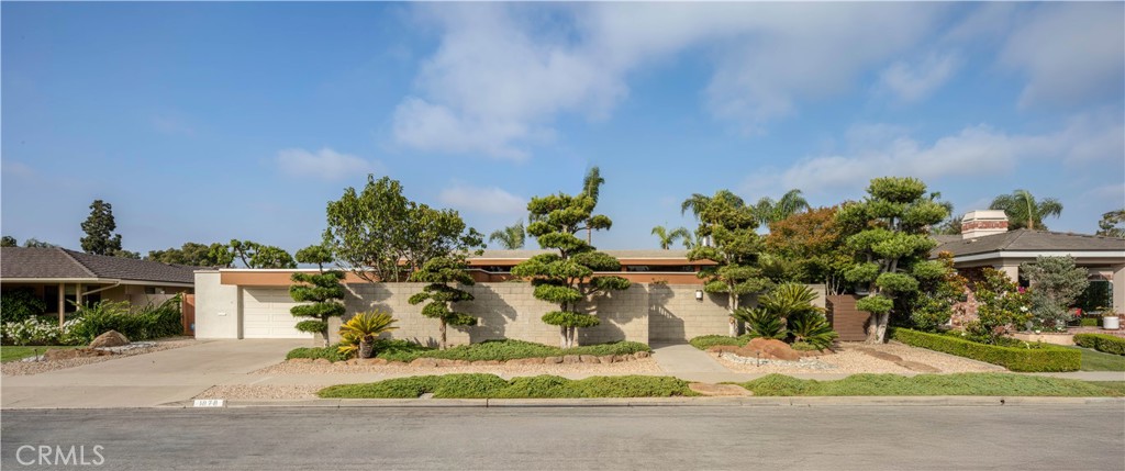 A true architectural gem in the heart of Mesa Verde, this mid-century modern residence was designed by renowned Laguna Beach architect Morris Skenderian, AIA to embrace light, landscape, and lifestyle. Envisioned with signature clean lines and an effortless connection to its natural surrounding, this 4-bedroom, 3-bathroom home offers 2,822 square feet of timeless living on an expansive 10,670 square foot lot just steps from the private entrance of Mesa Verde Country Club. Defining the design throughout is a glass façade that blurs the line between indoors and out. Glass walls and striking corner glass dissolve boundaries, inviting natural light to flood the interiors while framing lush views of the sprawling, private backyard. Here, a sparkling pool, ample room for multiple sitting areas, and a covered patio create a private retreat for both lively entertaining and quiet relaxation. Inside, Skenderian’s mastery of form and function comes to life with a soaring warm wood barrelled ceiling, clean lines, ribbon windows and flowing spaces.The living room is anchored by a dramatic stained-glass fireplace glowing with artistry, while the dedicated dining room is framed by a wall of glass, letting in light and views to the zen garden, while a clever passthrough window connects directly to the kitchen for effortless hosting. A true office and an additional den offer versatility for modern living while an oversized laundry room adds practicality. Rarely does a home unite architectural pedigree, expansive outdoor living, and a setting of such tranquility. This Skenderian-designed gem offers the best of Mesa Verde: timeless design, effortless connection to nature, and a location at the heart of one of the community’s most coveted enclaves.