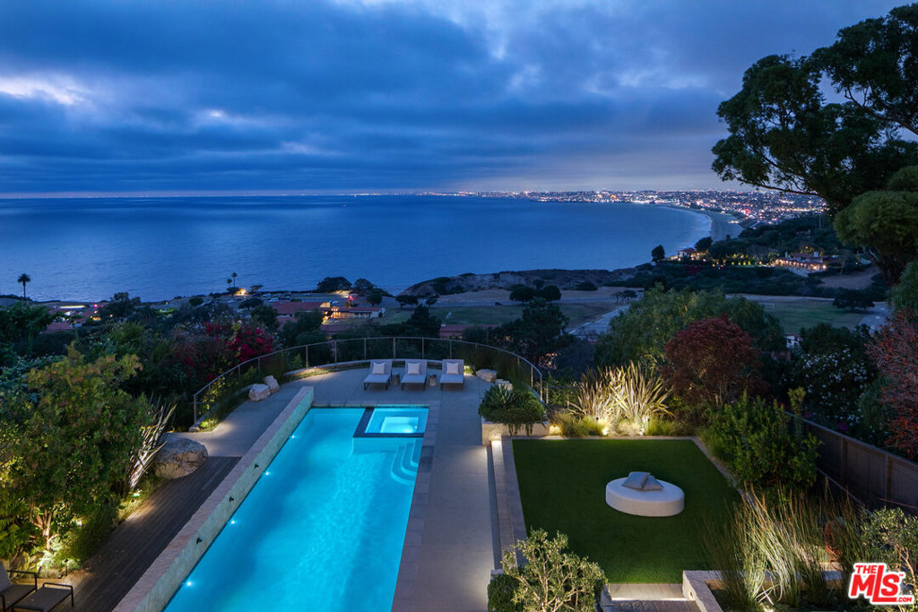 Showcasing breathtaking panoramic ocean views, this quintessential estate is set above the coastline in the heart of Malaga Cove. Offering unparalleled luxury, exquisite finishes, soaring ceilings, and advanced technology, the home boasts ~6,000 square feet with 5 bedrooms, 7 bathrooms and an elevator with custom stonework servicing all 3 levels. The masterfully designed open floor plan features several incredible living/entertaining spaces all with views, a chef's kitchen with top-of-the-line appliances, informal dining, a bonus room with an additional kitchen, and movie theatre. Walls of glass vanish throughout both levels allowing for a seamless flow from the inside of the home to the outside. California living at its finest. The stunning master suite is second to none with wood beam ceilings, an expansive private balcony, a spa-like bathroom with a free-standing tub, and 2 walk-in closets. Unmatched outdoor living hosting an expansive pool, spa, several patios + balconies, a fire pit, built-in BBQ, a dining area, ample lounge space, and a large grass area.