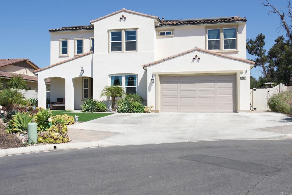 A picturesque California modern mission-style residence is situated within the renowned and charming gated Oak Creek community of twenty-four spacious homes without Mello-Roos. Vista, a community nestled within San Diego County, stands as a rare gem, offering residents a unique blend of urban and rural charm and an unspoiled natural environment. This charming residence is nestled amidst scenic hills and lush greenery where the community offers a harmonious blend of tranquility and modern living. It is an ideal choice for families, retirees, and individuals seeking respite from the urban lifestyle. This meticulously designed residence shows custom finishes seamlessly integrated throughout the 5 bedrooms and 4 bathrooms, which includes a first floor en-suite and second floor owner’s en-suite. The residence boasts well-maintained interiors, tasteful contemporary upgrades along with meticulous touches featuring a gourmet chef kitchen, huge island, walk-in pantry, dining space, and laundry room with sink. Generously equipped with fully paid solar and EV hookup. Plenty of natural lighting, open floor plan, security system, and storage. Owner suite includes a beautiful en-suite with separate vanities and closets as well as a bathtub over looking the greenery of Vista’s natural preserve. The property offers breathtaking northern views of the greenbelt foothills, stretching from the hilltop to Buena Creek. The expansive property offers ample outdoor entertainment, including the availability of a heated saltwater pool, spa, modest waterfall, and outdoor kitchen bar. A fully fenced entertaining property features exceptionally manicured landscape, fruit trees, covered patio, natural gas fire pit lounging area, and an entertaining outdoor kitchen offering, mini-fridge, bar sink, ice maker, grill and plenty of counter space. A tranquil oasis coupled with a flat level yard making this home fit for the most discerning occupant. This home is set to please most outdoor enthusiasts situated as a gateway to numerous hiking trails and nature reserves, perfect for exploring the stunning north county San Diego countryside. This home is conveniently located in close proximity to a major highway allows for easy access to downtown Vista, golf courses, nearby parks, recreational facilities, a variety of shopping and dining options, and the beautiful beaches of the southern west coast.