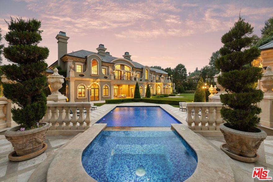 Nestled within the exclusive, guard-gated enclave of North Beverly Park, this masterfully crafted French Chateau evokes timeless elegance and refined sophistication. Set on approximately two manicured acres, the estate is enveloped by mature trees, tailored hedges, vibrant rose gardens, and expansive lawns, creating a serene and private outdoor sanctuary.  A grand motor court welcomes guests, framing the stately facade adorned with classical architectural details. Inside awaits the double-height entryway with intricate wrought iron detailing, gleaming marble floors, and a sweeping spiral staircase offering an ideal backdrop for elegant gatherings and grand entrances.  An array of exquisite features sets the tone for effortless luxury throughout: glittering chandeliers, French doors that flood the space with natural light, and Corinthian columns accented with gold leaf. The formal living room, with an ornate stone fireplace and rich wood flooring, offers an inviting ambiance for both intimate and grand-scale entertaining. Adjacent, the parlor/library provides a quiet retreat for study or relaxation.  The chef's kitchen is a culinary masterpiece, boasting dual oversized islands, professional-grade Viking appliances, a custom refrigerator, and a double chef's range. A sunlit breakfast room opens to the enchanting rear gardens, while the formal dining room, sets the stage for memorable occasions.  The family room, complete with a fireplace and entertainment center, is ideal for everyday comfort, while the private screening room and snack bar offers an unparalleled cinematic experience.  Upstairs, the palatial primary suite features soaring 20-foot ceilings, a private balcony, and dual spa-inspired bathrooms equipped with rain showers, jetted tubs, and custom vanities.  The exterior of the estate is a perfect retreat offering both comfort and grandeur.  The pool and spa evoke the charm of a European retreat, complemented by a stately ballroom for hosting unforgettable events. A lighted regulation-size sport court accommodates tennis and basketball, while the meticulously curated rose garden provides a tranquil escape.  Designed with the highest standards of privacy and security, this extraordinary residence offers not just a home but a lifestyle of unmatched comfort, prestige, and sophistication.