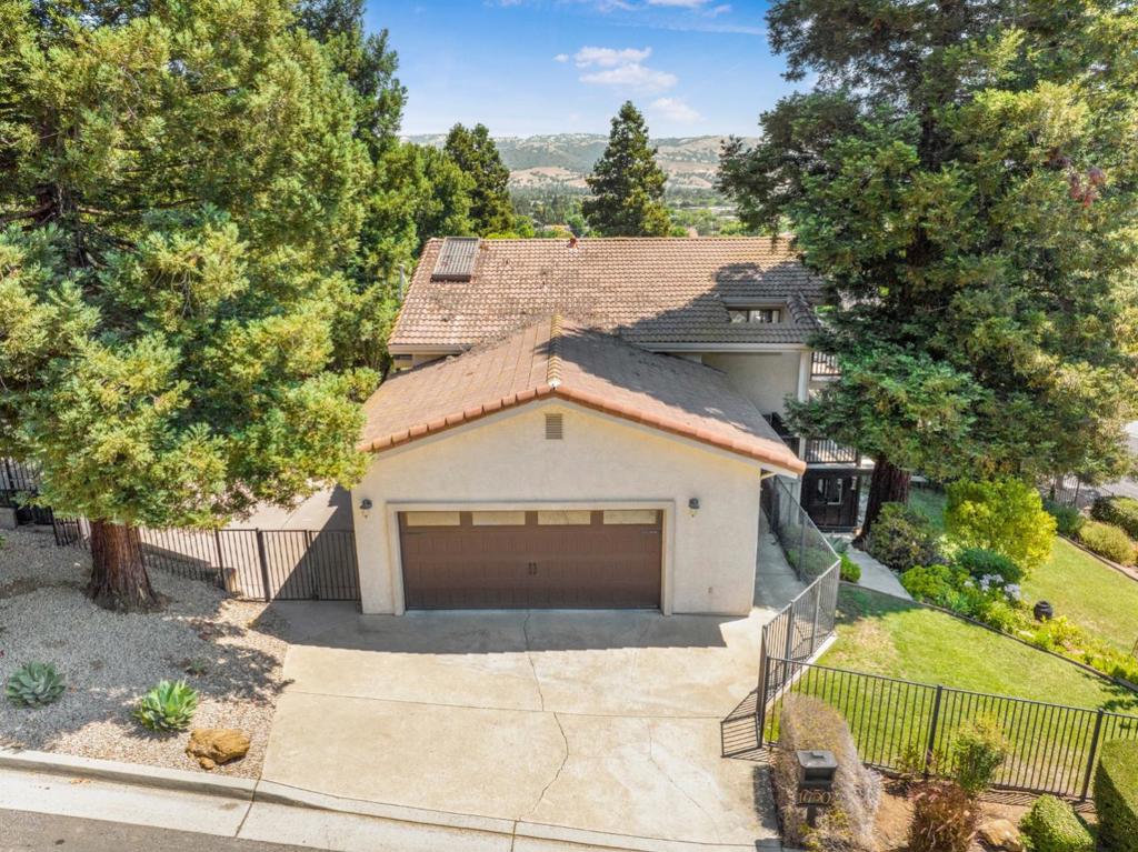 Welcome to 17750 Trumpp Court, a sophisticated residence gracefully set on a gently elevated corner lot on the West Side of Morgan Hill. This distinctive setting offers scenic views from most windows and spectacular city light vistas from the upper-level east-facing windows, creating serene moments of beauty throughout the day and into the evening. Framed by four majestic redwoods, the home feels like a secluded retreat, blending privacy with natural charm. Built with high-grade lumber and copper piping throughout, it reflects quality craftsmanship inside and out. The main living area offers 1,808 square feet of thoughtfully designed space, featuring three spacious bedrooms and 2.5 tastefully appointed bathrooms. Beyond the primary living space, the custom-built home includes a finished attic, ideal as a playroom or for extra storage, and a converted basement that provides flexible bonus space to suit a variety of needs. A two-level wrap-around porch invites relaxed outdoor living and entertaining, while the interior is adorned with a stunning chefs kitchen, perfect for hosting and everyday enjoyment. The professionally landscaped yard features a variety of fruit trees, a basketball court for recreation, and plenty of room to unwind. Set on a 7,720 square foot lot.