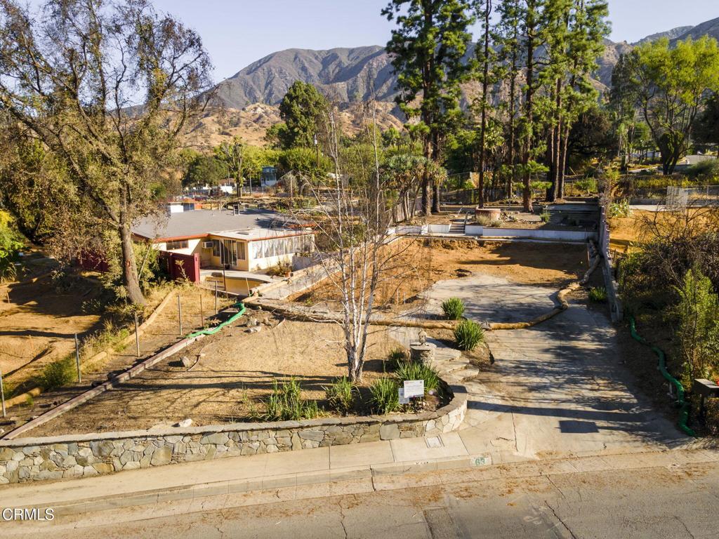 Perched in the Altadena foothills with sweeping views toward Downtown Los Angeles and north to the San Gabriel Mountains, this 9,338 square foot parcel (per assessor) offers a rare opportunity to bring your vision to life. Measuring approximately 161 feet deep by 58 feet wide, the lot's impressive depth is one of its many unique features, providing flexibility for your custom residence, expansive gardens, or outdoor living spaces.Additionally, this property is home to seven mature Canary Island Pines that dot the rear of the lot, creating a natural rustic backdrop of beauty and shade. Nestled among the pines, a concrete patio offers a ready-made outdoor entertaining area - an inviting spot to enjoy the foothill setting even before construction begins. A striking Dragon Tree adds additional character and charm, while a gorgeous stone retaining wall anchors the front of the property, adding timeless curb appeal.Located within the Eaton Fire area, the land has been cleared, resulting in open vistas and a few immediate neighbors. Its elevated position captures both the surrounding mountain landscape and the twinkling city lights to the south. Buyers are advised to verify all development details, zoning, and utility access with Los Angeles County and local providers.Enjoy the best of Altadena living - with close proximity to hiking & biking trails, JPL, and the thriving Lincoln & Lake Avenue businesses, while only minutes to Old Town Pasadena, the Rose Bowl, and freeway access into DTLA.A rare foothill parcel combining size, views, and distinctive natural features - ready to become something truly special.Please drive by only and no trespassing onto the property.