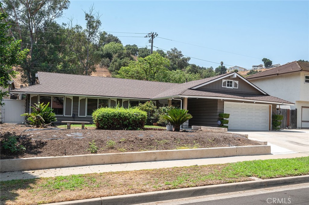 This private Diamond Bar Ranch-style residence is situated on a large private lot in a cul-de-sac neighborhood. Gracious double-door entry to a large foyer leading to the step-down living room with a charming fireplace. The kitchen is a gorgeous 2021 remodel. Quartz countertops, tile backsplash, and recessed lighting wth an under-mount sink. Totally custom cabinetry, including a handy "lazy susan" corner cabinet. The culinary island includes ample seating, storage, a six-burner Thermador range, and an exhaust hood. Built-in Kitchen Aid double ovens with a top-of-the-line refrigerator, Thermador dishwasher, PLUS drawer-style microwave complete the appliance package. The center island offers ample storage for those small appliances and decor that are not often used. Speaking of storage, do not overlook the walk-in pantry installed in 2010 with custom shelving! The kitchen sewer line was sleeved in 2019. Direct access to the kitchen is from the two-car garage. You'll find the laundry, the water softener (paid for in 2020), and the oversized water heater (2022). Off the glamorous kitchen is a large dining area which opens to the family room for ease of entertaining. The family room has beamed vaulted ceilings and sliding doors to the covered patio. Remodeled in 2022, this patio space has newer concrete that spans the whole rear and side of the home. Also included in the 2022 remodel is fresh hardscape with seating and tiered planters with steps to the sloping hillside, ready for your gardening touch. The primary bedroom, bathroom, and one bedroom were reimagined in 2020 to create a dream retreat. The primary bathroom has custom tile throughout with a large walk-in shower with glass doors. There is a lovely skylight for ambient lighting and a massive walk-in and walk-through closet with a custom storage system. There are three other spacious bedrooms and a bright hall bathroom as well. Enjoy the newer dual-pane vinyl windows (2020) and relax in the climate-controlled environment thanks to the 2022 HVAC system. Tesla solar system installed in 2014 on the 2022 roof! More than just a property, this home has been lovingly cared for and updated - ready for you to enjoy!