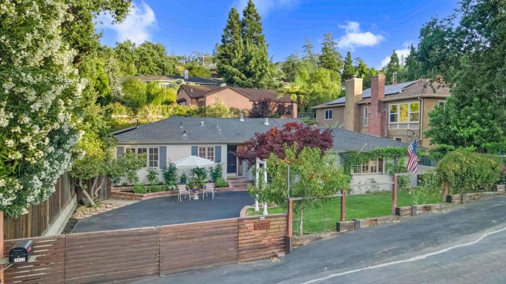 Tucked behind a private gate and set back from the street, 3037 Hopkins Avenue blends luxury, comfort, and privacy in the heart of Redwood City. A newly paved driveway leads to this reimagined single-level home with thoughtful upgrades and sophisticated finishes throughout. The chef's kitchen features granite countertops, a Bertazzoni gas range, Bosch dishwasher, Frigidaire refrigerator, wine cooler, recessed lighting, and sunlit windows. Hardwood floors and a classic fireplace anchor the open living and dining areas. Sliding doors open to a resort-style patio with a built-in gas BBQ, bar, wall-mounted TV, radiant heater, sink, and beverage fridge perfect for entertaining. Mature landscaping, exotic plants, and fruit trees (peach, plum, nectarine, and quince) surround the home in lush privacy. The flexible second bedroom works as a nursery, an office or guest suite, while the serene primary suite offers a spa-like bath and backyard access. A 6-person jacuzzi with cascading waterfalls and a pergola-covered lounge complete this outdoor escape. Ideally located near Caltrain, highways 101 & 280, El Camino Real, Red Morton Park, downtown, and top employers including Meta, Oracle, EA, and Stanford, this luxurious and inviting retreat captures the essence of Peninsula living.