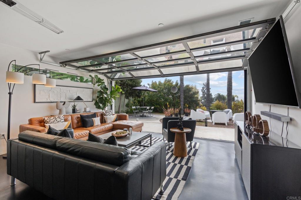 A stunning contemporary masterpiece, this modern home with an industrial flair effortlessly captures the essence of coastal living. Rebuilt in 2020, the four-bedroom, four-and-a-half-bath residence has been thoughtfully designed to maximize natural light and create a seamless indoor-outdoor experience. Located west of I-5 in beautiful Solana Beach, the home offers peek-a-boo ocean views from the rear garden and driveway—making this a prime location. Elegant design elements elevate the space, including eight-foot solid wood frameless doors imported from Italy and a custom front door crafted in Poland. Throughout the home, polished concrete floors with black dye treatment and a satin finish add a sleek, contemporary touch. The custom insulated industrial-style garage door adds a dramatic and unexpected focal point to the family room, while also offering direct access to the rear garden. Inside and out, all walls are hand-troweled, enhancing the home’s minimalist beauty and craftsmanship. The overall energy is calm and serene—where modernity and tranquility coexist in harmony. Each of the four spacious bedrooms includes its own en suite bathroom, complemented by a stylish powder room and functional laundry space that continue the home’s cohesive, contemporary aesthetic. A smaller bonus room near the entrance is perfect as a home office, gaming area, or cozy reading nook—tailored to your needs. The expansive family room is the heart of the home—bright, inviting, and opening to the backyard for effortless al fresco dining in San Diego’s perfect weather. There's ample space to add a pool or even an ADU, offering future potential. Designed with a second story in mind, the home can accommodate an additional 1,500 sq. ft. (subject to buyer seeking permits if desired), which would offer stunning panoramic ocean views. A virtual rendering of this potential expansion is available through the listing agent. While the current kitchen was conceived as a temporary design—originally meant to be relocated upstairs—it is fully functional and stylish, featuring LG stainless steel appliances that make entertaining a joy. Set back from the street in a quiet cul-de-sac, the home offers both privacy and a welcoming presence. The rear yard extends beyond the current landscaping, providing room to build an extended deck or additional outdoor living space. A two-car garage rounds out the home. With no HOA, a top-tier school district, easy beach access, and proximity to all local amenities, this is the perfect place to call home.