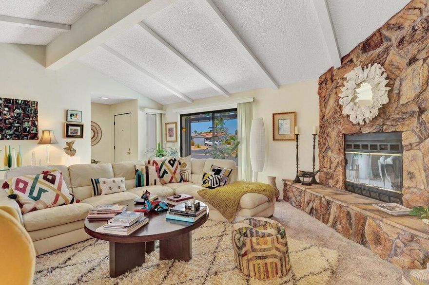 RARE CORNER LOT in Portola Country Club - YOU OWN THE LAND! Located in the desirable gated, active adult community of Portola Country Club (55+), this spacious 1,931 sq ft 3-BEDROOM + DEN, 2-Bath home offers a bright open layout, rare corner lot privacy, and outstanding community amenities. Ownership includes GOLF PRIVILEDGES FOR TWO and a LOW HOA fee covering Spectrum internet, access to the newly remodeled clubhouse, pools/spas, tennis, pickleball, fitness center, Pub, and more. The inviting open floor plan features a striking floor-to-ceiling stone fireplace at the living room, a dining area with a built-in china cabinet, a well-appointed kitchen and TWO COVERED PATIOS perfect for indoor-outdoor living. The primary suite boasts a WALK-IN CLOSET, dual vanities, soaking tub, separate shower, and private toilet room. The den--with SKYLIGHT--is ideal for an office or hobby space. Additional highlights include a TWO-CAR GARAGE with a picture-window view of the mountains and plenty of natural light, a covered carport for extra parking, a spacious laundry room with washer/dryer included, and plenty of STORAGE SPACE! All this in a friendly, centrally located Palm Desert golf community close to El Paseo, College of the Desert, medical, shopping, dining, and entertainment. Enjoy resort-style living, the views, and the lifestyle! Sold AS-IS!!!