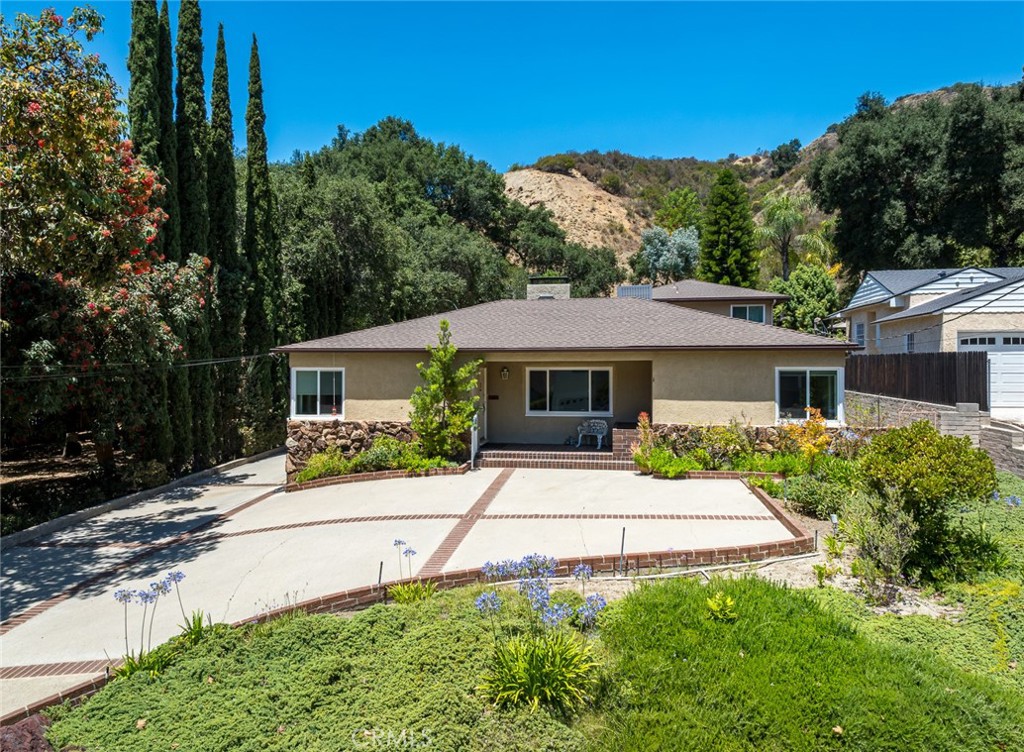 Welcome to 2719 Hollister Terrace – Timeless Character Meets Modern Comfort in Glenoaks Canyon. Nestled on nearly half an acre in the serene and highly sought-after Glenoaks Canyon neighborhood, this beautifully maintained 3-bedroom, 4-bathroom residence offers 3,499 square feet of thoughtfully designed living space. With a flexible layout and a permitted bonus living area above the garage—including its own bathroom and bar—this home is ideal for guests, a home office, or future ADU conversion. Originally built in 1939, the home exudes classic architectural charm, complemented by modern updates for today’s lifestyle. Recent upgrades include a new roof (2020), new 5-ton HVAC system (2020), and dual-pane windows (2020), ensuring comfort and peace of mind. Inside, you’ll find formal living and dining rooms, a cozy fireplace, and large windows that bathe the home in natural light. The layout flows seamlessly, making it perfect for both everyday living and entertaining. Step outside to an expansive backyard—offering over 20,000 square feet of flat, usable space. Whether you dream of adding a pool, expanding the living area, or creating your own private outdoor oasis, the possibilities here are endless. Located in one of Glendale’s most picturesque and peaceful neighborhoods, this home is within an excellent school district and just minutes from hiking trails, Scholl Canyon Golf Course, local parks, and major freeways for easy access across the city. 2719 Hollister Terrace is a rare find—offering space, flexibility, and timeless charm in one of Glendale’s most treasured canyon communities