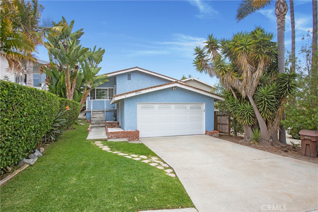 Live the coastal life in Capistrano Beach – Charm, comfort, and location! Enjoy the best of South Orange County living in this Capistrano Beach charmer, ideally located near Dana Point Harbor, Doheny State Beach, and the San Clemente Outlets. With beaches, dining, and recreation just minutes away, this home offers the lifestyle you've been waiting for. This split-level home features central air conditioning, a rare luxury in a coastal beach community, oak wood flooring, crown molding, Milgard double-pane noise-reduction windows, wood blinds, carpeting in the bedrooms, and an open floor plan. The updated kitchen features granite countertops, stainless steel appliances including a Whirlpool refrigerator and LG microwave, soft self-closing drawers, a corner cabinet lazy Susan, a spice carousel, a newer gas range, and a sleek stainless steel/glass range hood. Relax in the cozy living room by the fireplace or step outside to your private wood deck and backyard—ideal for morning coffee, evening wine, or simply catching coastal breezes. The primary suite offers direct backyard access and a private en-suite bathroom, while two additional bedrooms feature mirrored wardrobes and ample natural light. The hallway bath features a walk-in shower, a designer glass bowl sink, and linen storage. The two-car garage houses the washer and dryer, a newer water heater, and has a newer LiftMaster garage door opener and convenient keypad entry. Low tax rate, no HOA fees or Mello-Roos, close to freeway access for fast commuting and weekend getaways; this is a must see!