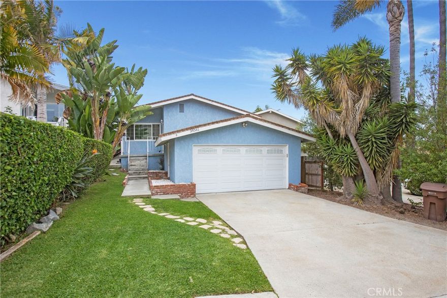 Live the coastal life in Capistrano Beach – Charm, comfort, and location! Enjoy the best of South Orange County living in this Capistrano Beach charmer, ideally located near Dana Point Harbor, Doheny State Beach, and the San Clemente Outlets. With beaches, dining, and recreation just minutes away, this home offers the lifestyle you've been waiting for. This split-level home features central air conditioning, a rare luxury in a coastal beach community, oak wood flooring, crown molding, Milgard double-pane noise-reduction windows, wood blinds, carpeting in the bedrooms, and an open floor plan. The updated kitchen features granite countertops, stainless steel appliances including a Whirlpool refrigerator and LG microwave, soft self-closing drawers, a corner cabinet lazy Susan, a spice carousel, a newer gas range, and a sleek stainless steel/glass range hood. Relax in the cozy living room by the fireplace or step outside to your private wood deck and backyard—ideal for morning coffee, evening wine, or simply catching coastal breezes. The primary suite offers direct backyard access and a private en-suite bathroom, while two additional bedrooms feature mirrored wardrobes and ample natural light. The hallway bath features a walk-in shower, a designer glass bowl sink, and linen storage. The two-car garage houses the washer and dryer, a newer water heater, and has a newer LiftMaster garage door opener and convenient keypad entry. Low tax rate, no HOA fees or Mello-Roos, close to freeway access for fast commuting and weekend getaways; this is a must see!