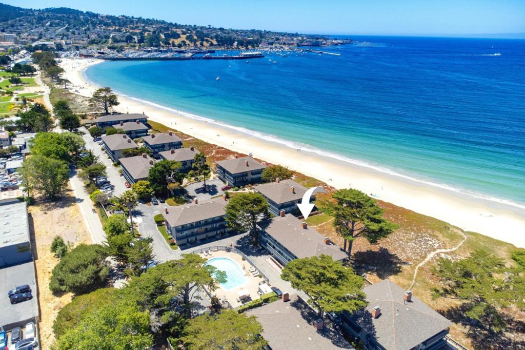 Experience stunning unobstructed OCEANFRONT views from this coastal retreat located in the gated La Playa Townhomes on Del Monte Beach, one of Monterey's rare oceanfront communities Located just steps to the sand, this two-bedroom, 2.5-bath townhouse + bonus room is designed to embrace the breathtaking ocean views and sounds. The living room features a gas fireplace, and expansive floor-to-ceiling windows with a sliding glass door that captures endless views. Upstairs enjoying the panoramic views spanning from Monterey Harbor to Santa Cruz, complete with private balcony and ensuite bath. The second bedroom features an ensuite bath and private balcony with sliding glass door overlooking a sparkling swimming pool. Freshly painted interiors and a tastefully updated kitchen features granite countertops, oversized built-in refrigerator and under counter wine refrigerator. Downstairs, the flexible bonus room with half bathroom can serve as extra space for guests, home office, or studio. This move-in-ready beach retreat comes fully furnished and is within walking distance to the Wharf, restaurants, shops and steps to the 18-mile recreational trail. Don't miss the opportunity to own a rare piece of coastal paradise to enjoy for years to come.