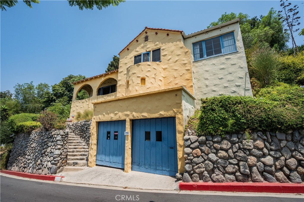 Located in the Adams Hills district, this enchanting Mediterranean haven whispers the romance of the Old World while embracing the vibrant Los Angeles lifestyle with open arms. Originally crafted in 1925, you’re warmly welcomed by a stone staircase that sweeps you into a charming living room, where graceful arches frame breathtaking city views. The space glows with the timeless artistry by renowned artist Ernest Batchelder and soars with high, inviting ceilings. The cozy one-bedroom, one-bath retreat features a delightful ensuite study attached to the bedroom, a perfect nook for dreams and inspiration. Doors and windows, painted with a soft grayish blue and sun-kissed hues, yearn to be opened. Step into the idyllic alfresco dining area off the dining room, where candlelit dinners await under the stars, and enjoy yourself in the peaceful backyard, perfect for entertaining your cherished ones in a setting straight out of a Mediterranean fairytale.