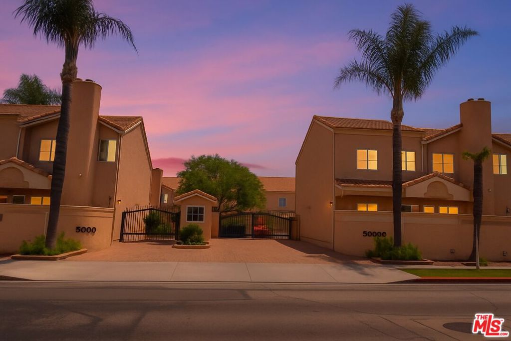 Nestled in one of the only gated condominium communities in the Valley offering 24/7 in-person security, this elegant 2-bedroom, 2.5-bath townhome blends comfort, style, and peace of mind. Located just a short stroll from Ventura Blvd with quick access to the 101 freeway, it offers the perfect balance of privacy and convenience. The spacious, open-concept living room features a fireplace and flows out to a private patio ideal for entertaining or quiet evenings. The main level includes porcelain tile flooring, a thoughtfully designed cook's kitchen, and an attached garage with direct access. Upstairs, both bedrooms are en-suite, with the primary suite offering a cozy fireplace and dual walk-in closets. Community amenities include a pool, spa, clubhouse, gym, and sauna. Ample storage throughout the home adds everyday functionality, and all utilities are included in the rent and paid by the landlord.