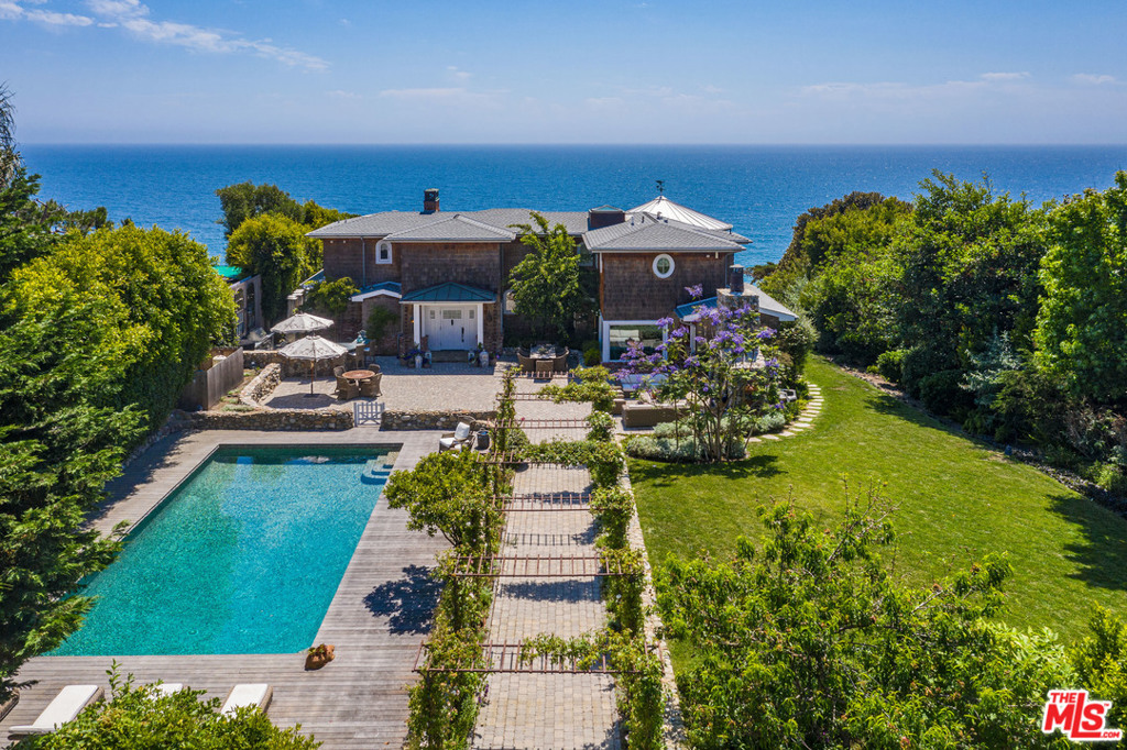 Situated on the Point Dume bluff, this ultra-private, Cape Cod-inspired estate designed by Doug Burdge, AIA offers spectacular ocean views and direct, gated beach access. The main house and guest cottage are surrounded by fruit trees and large grassy lawn. Flower-laden trellises frame the entry walkway to the pebble-tiled pool and entertainers patio, with a river rock stone fireplace and outdoor kitchen. Elegant interiors feature walnut floors, Carrera marble counters, casual and formal dining and glass pocket doors to the ocean-facing terrace. The 2nd-floor master suite boasts an ocean-view terrace, walk-in dressing room, and soaking tub. Steps from the main house lead down the hillside to the homes private sandy beach and the oceanfront below. Home features include surround sound, security system and a 3-car garage. From its commanding perch on Point Dume, the estate offers the utmost privacy and serenity in one of the most sought-after locations on the Southern California coast.