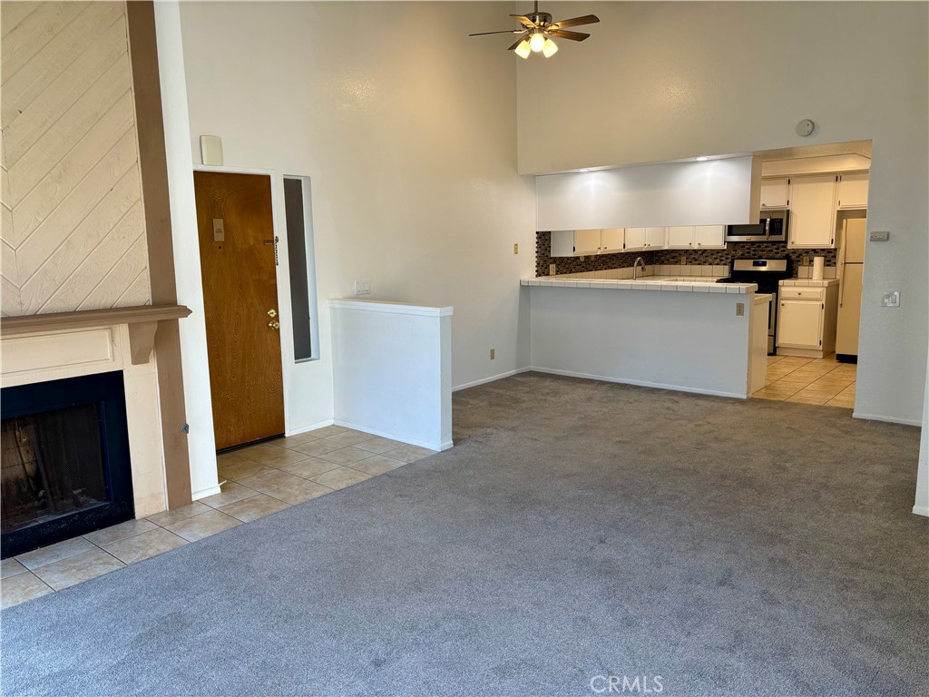 Welcome to this spacious and beautifully updated 1-bedroom, 1-bath top-floor condo in the private, gated Harbour Vista community of Huntington Beach. With elevator access, soaring vaulted ceilings, and an open floor plan filled with natural light, blends comfort, style, and convenience in one of Orange County’s most desirable areas. The living room features recessed LED lighting, a ceiling fan, and a cozy fireplace, with a large sliding glass door that leads to a breezy private balcony—perfect for relaxing or entertaining. The bright kitchen is equipped with stainless steel appliances and offers ample cabinet and counter space, while a separate laundry room just off the kitchen adds extra storage and functionality. The generously sized bedroom includes a walk-in closet, direct access to the balcony through a second sliding glass door, and an en-suite bath with a shower/tub combo. Additional highlights include a detached one-car garage, an assigned parking space, and the bonus of low monthly utility costs—you're only responsible for electricity, gas, internet, and cable. Harbour Vista offers peaceful, resort-like surroundings with meandering streams, tranquil water features, two pools and spas, a sports court, and picnic areas. Ideally located near Huntington Harbour, world-famous beaches, wetlands, shopping, dining, and countless outdoor activities—all within a secure, well-maintained community. Move-in ready and ideally located—don’t miss this opportunity!